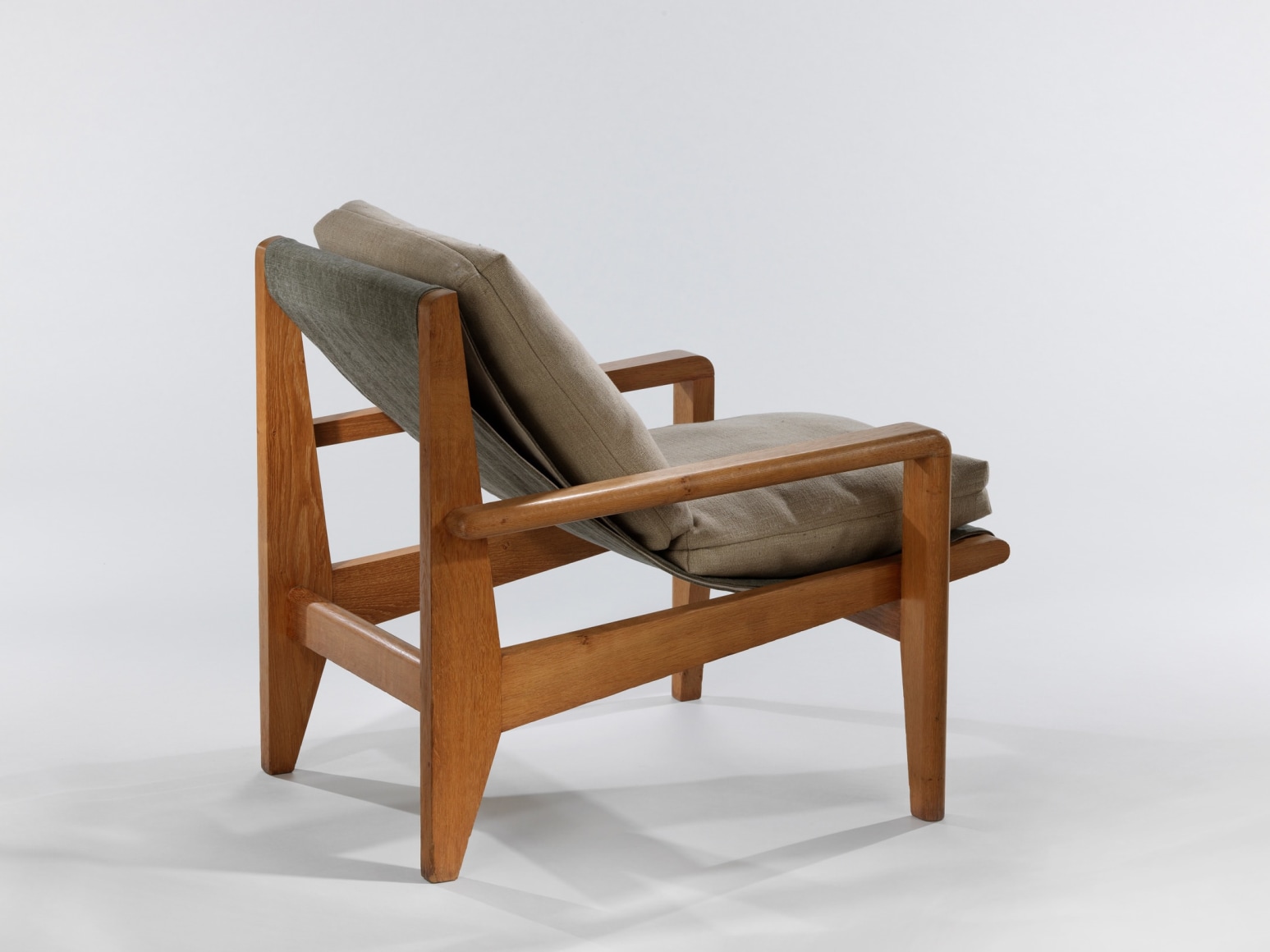 Back view of low wood armchairs with upholstered cushions on seat