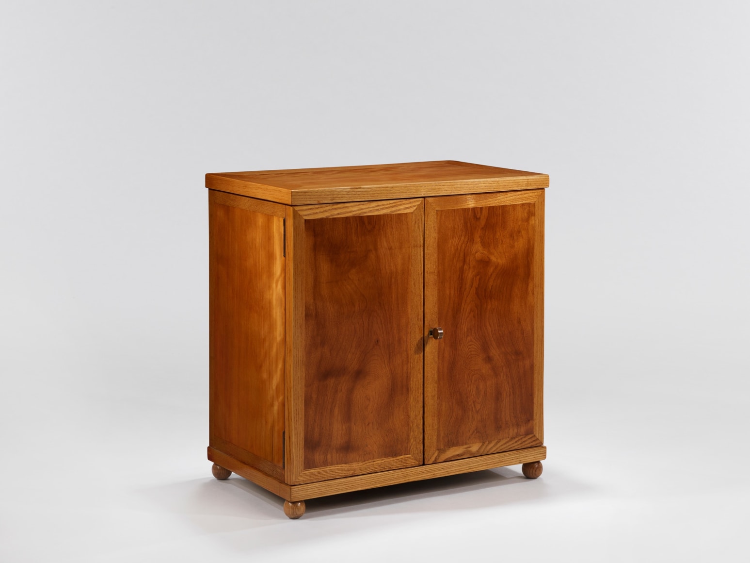 Wooden cabinet with rounded feet and brass pull