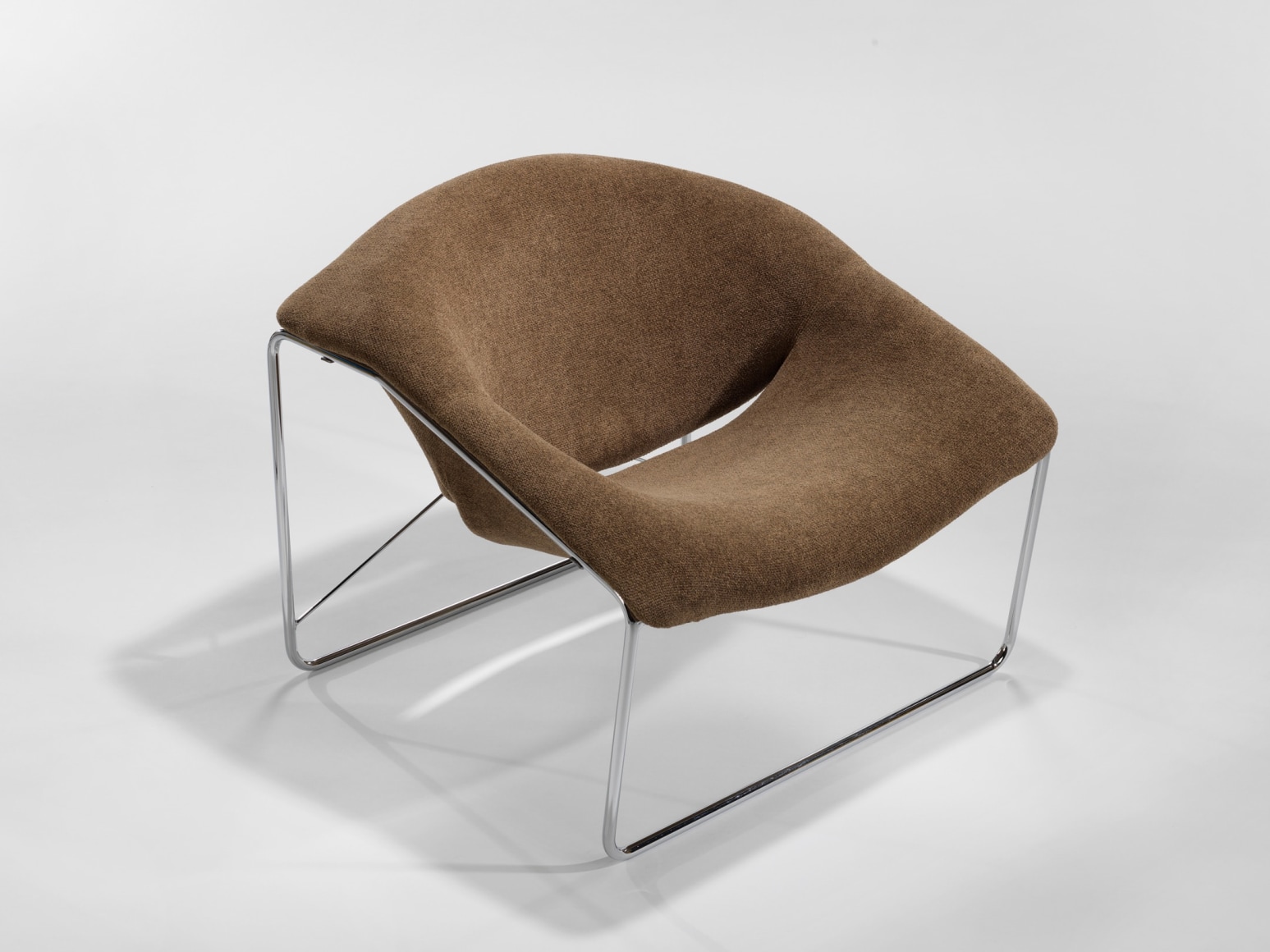 photograph of chair in a blank room with metal legs