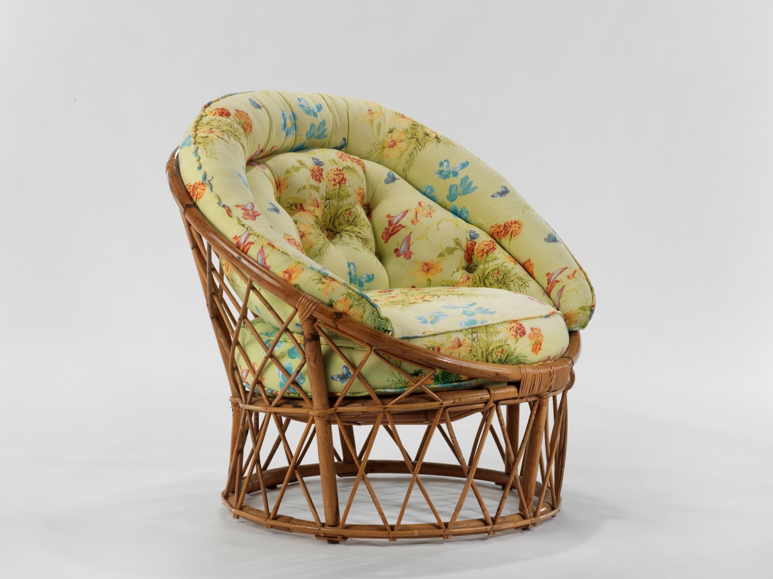 Cushion chair with floral motifs and wooden frame in front of white background