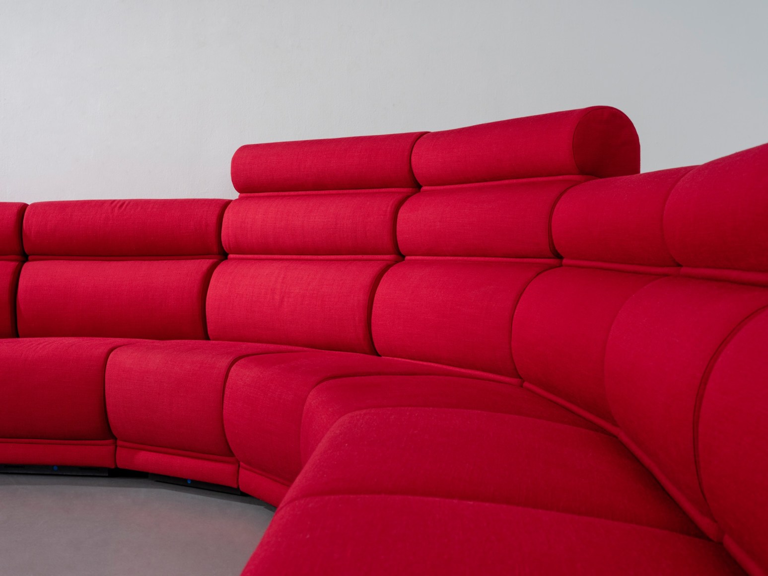 Red long huge sofa upholstered photo shots in a studio. Sofa is by Pierre Paulin.