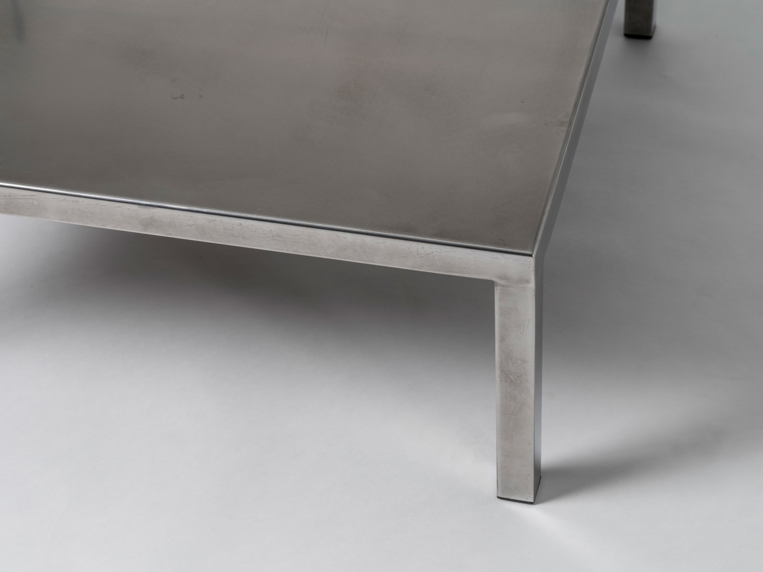 Corner detail of stainless steel low table by Maria Pergay