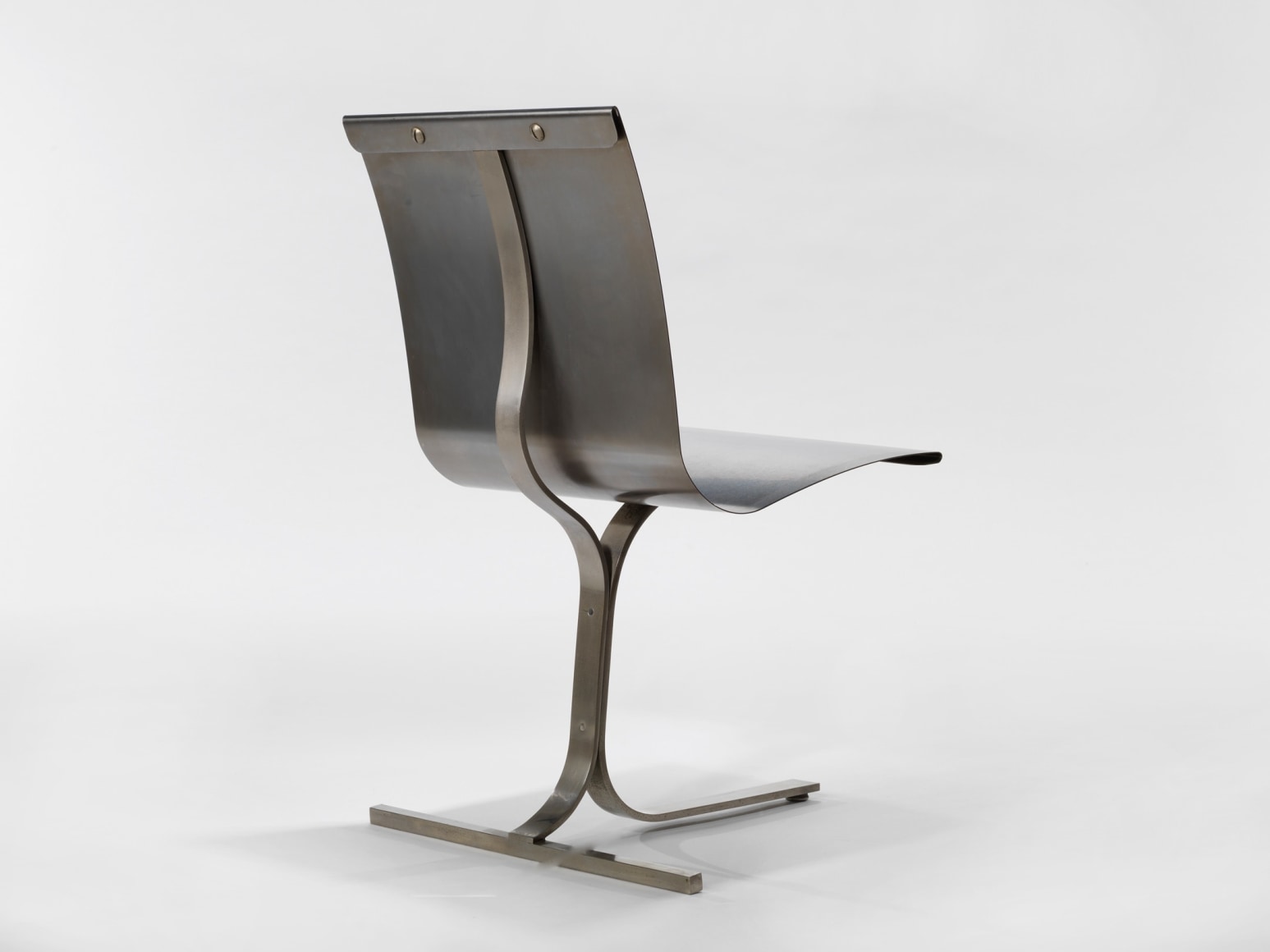 photograph of a blank room with a chair by Charpentier, made of steel