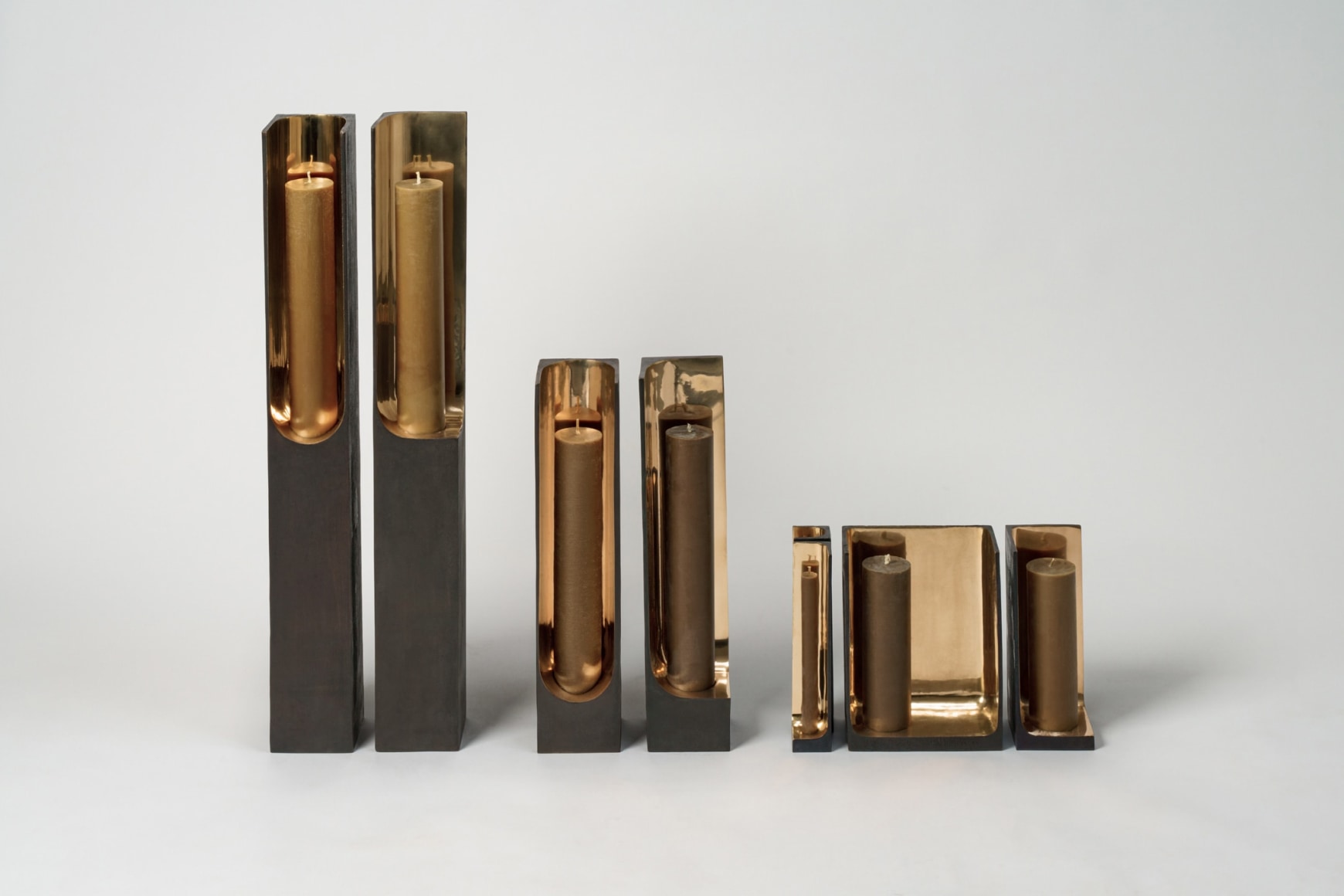 Bronze candlestick with gold detailing and black exterior.