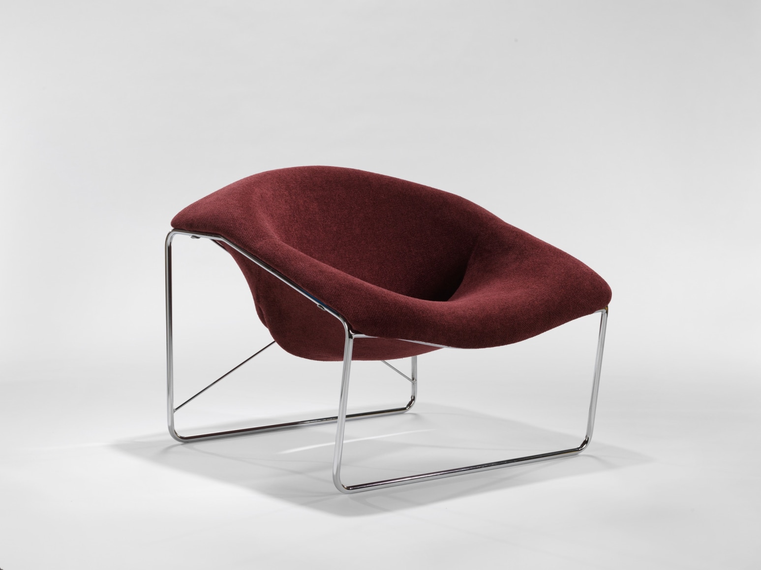 photograph of chair in a blank room with metal legs