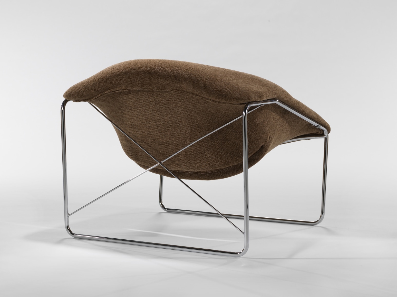 photograph of chair in a blank room with metal legs