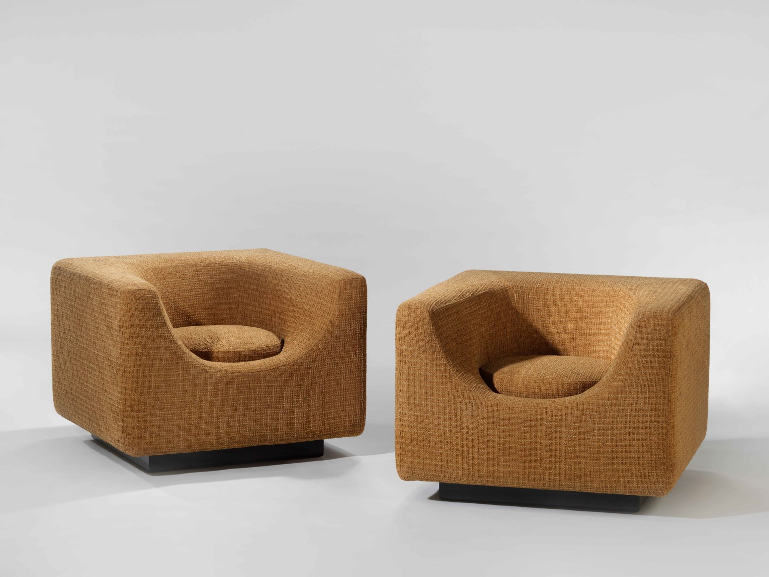 photograph of two brown armchairs in a room