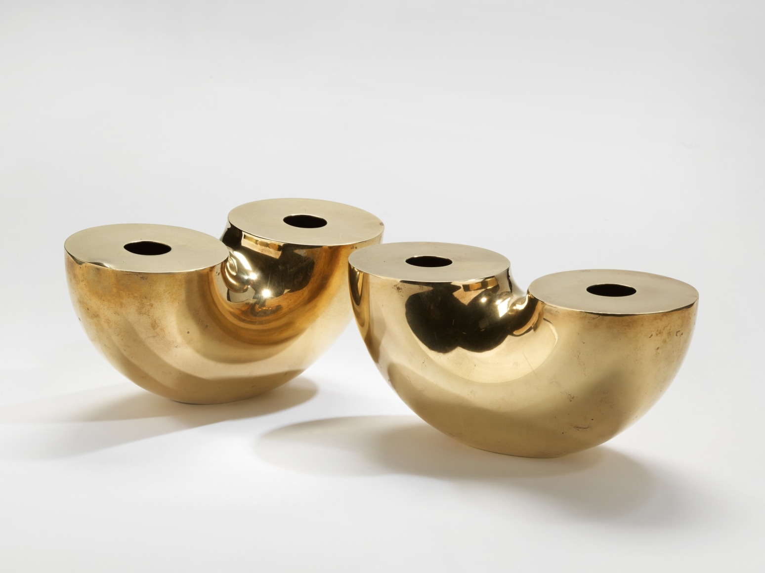 photograph of two gold vases in a blank room