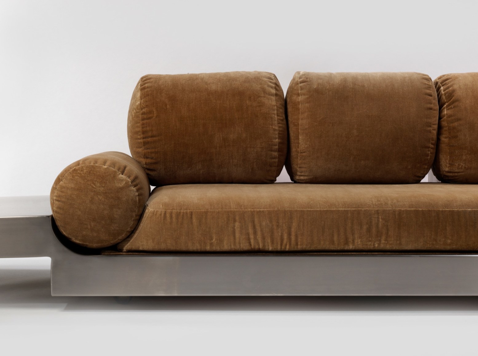 Detail close up of Maria pergay daybed with brown upholstery and steel frame.