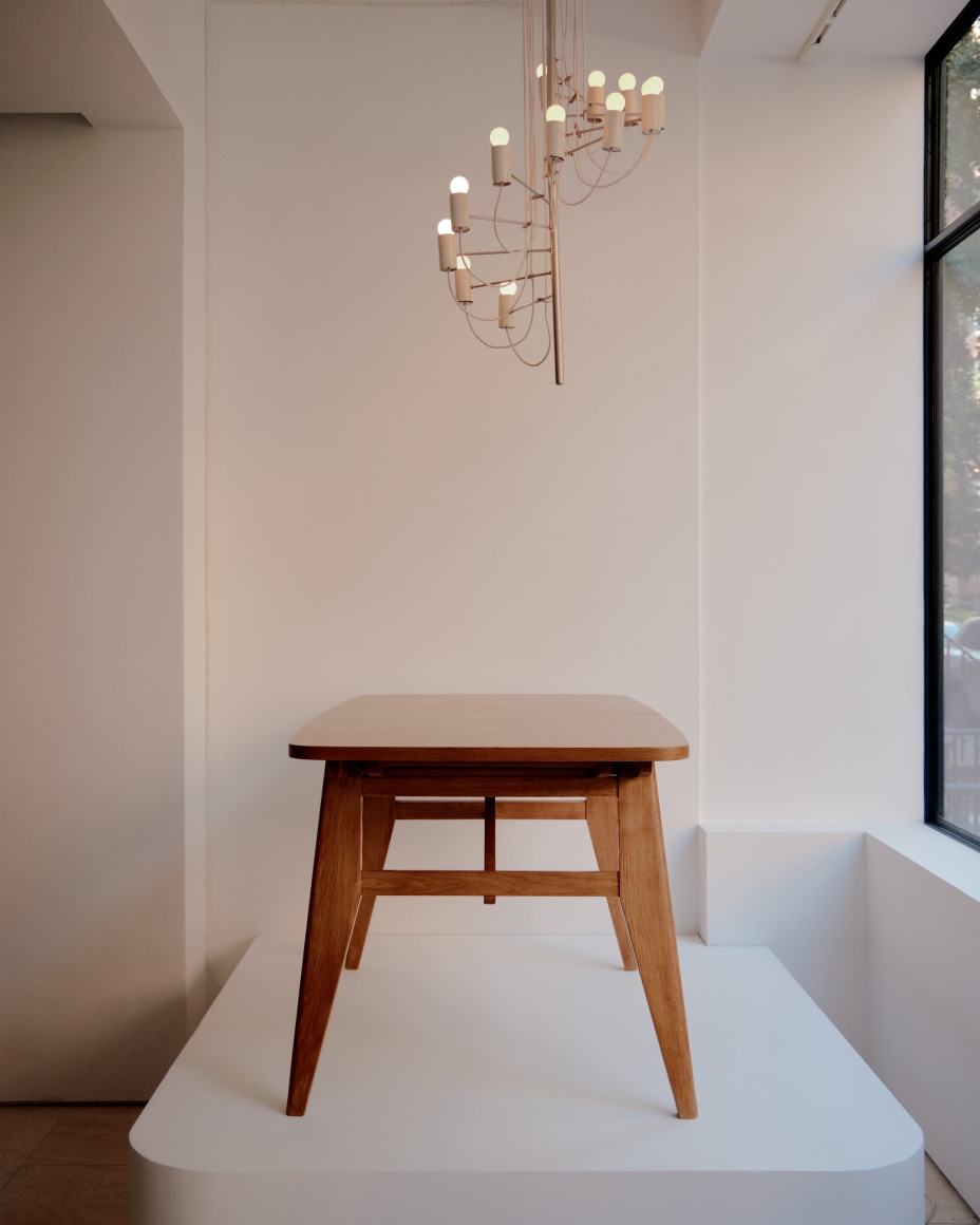Wooden dining table by Ren&eacute;-Jean Caillette and metal ceiling lamp by Alain Richard above