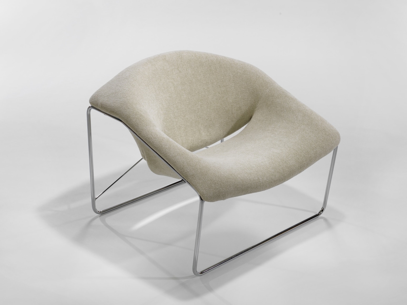 photograph of chair in a blank room with metal legs