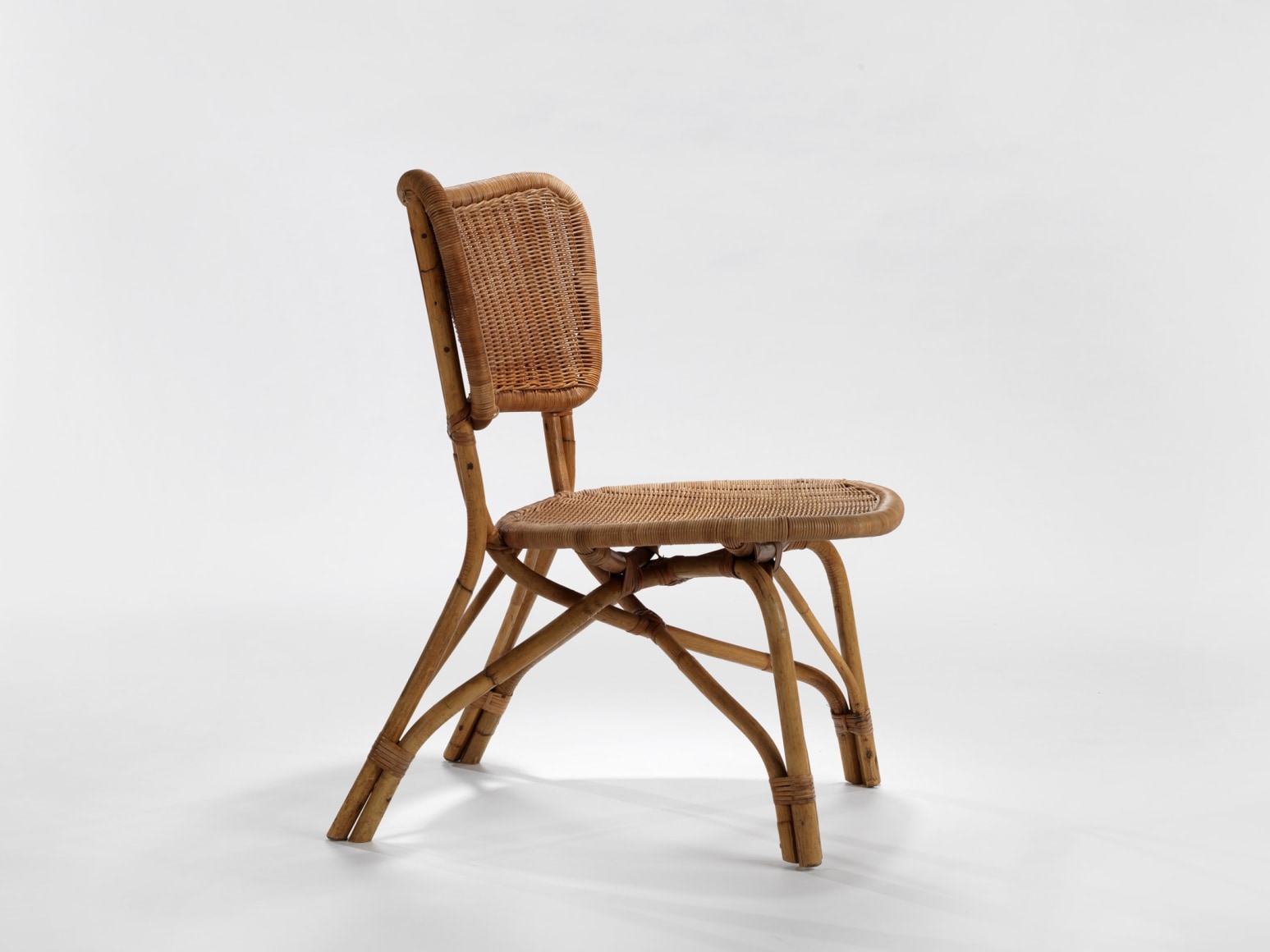 photograph of a rattan chair in a blank room