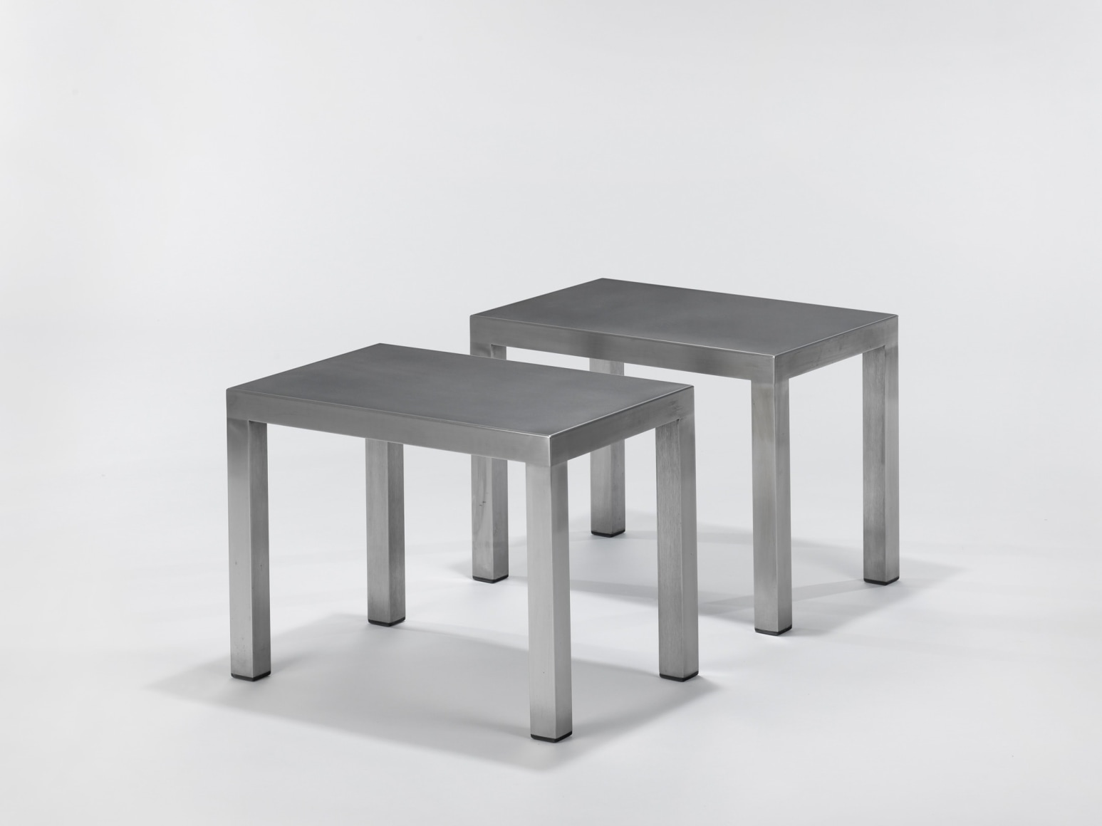 Stainless steel end tables in frond of white background