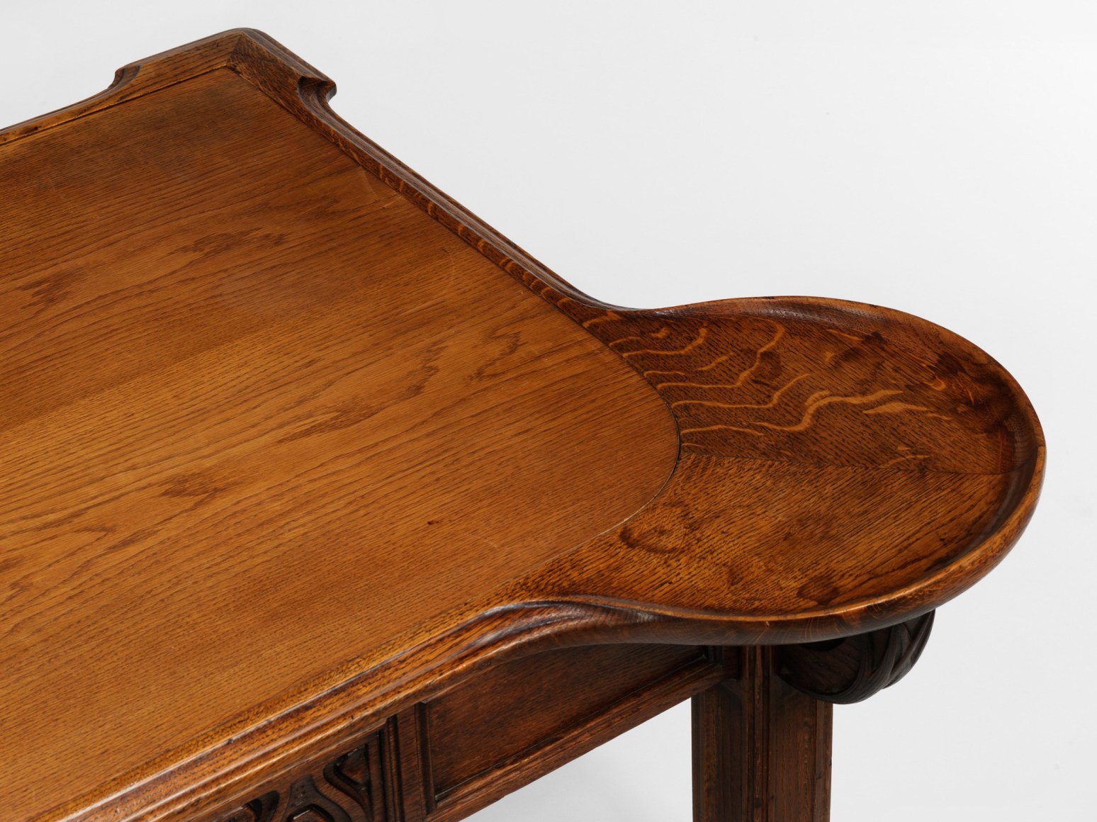 photograph in blank room of desk by Gauthier made in wood with detailing throughout, four legs and drawers.