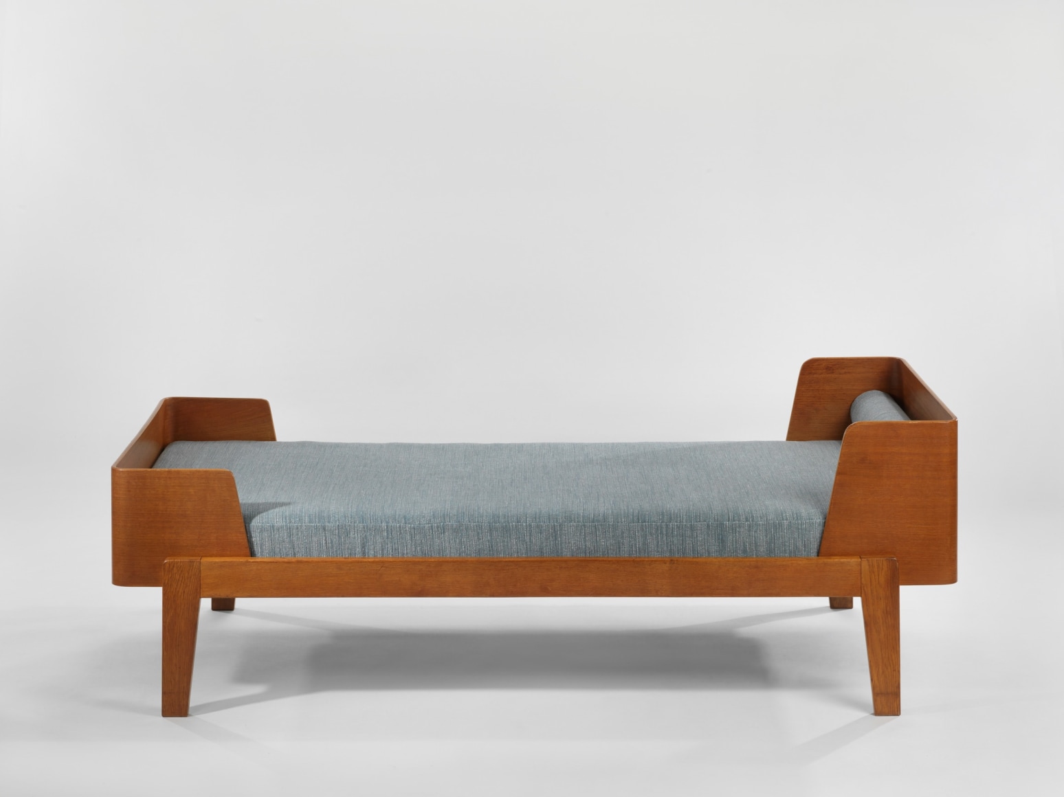 wood daybed in an empty room