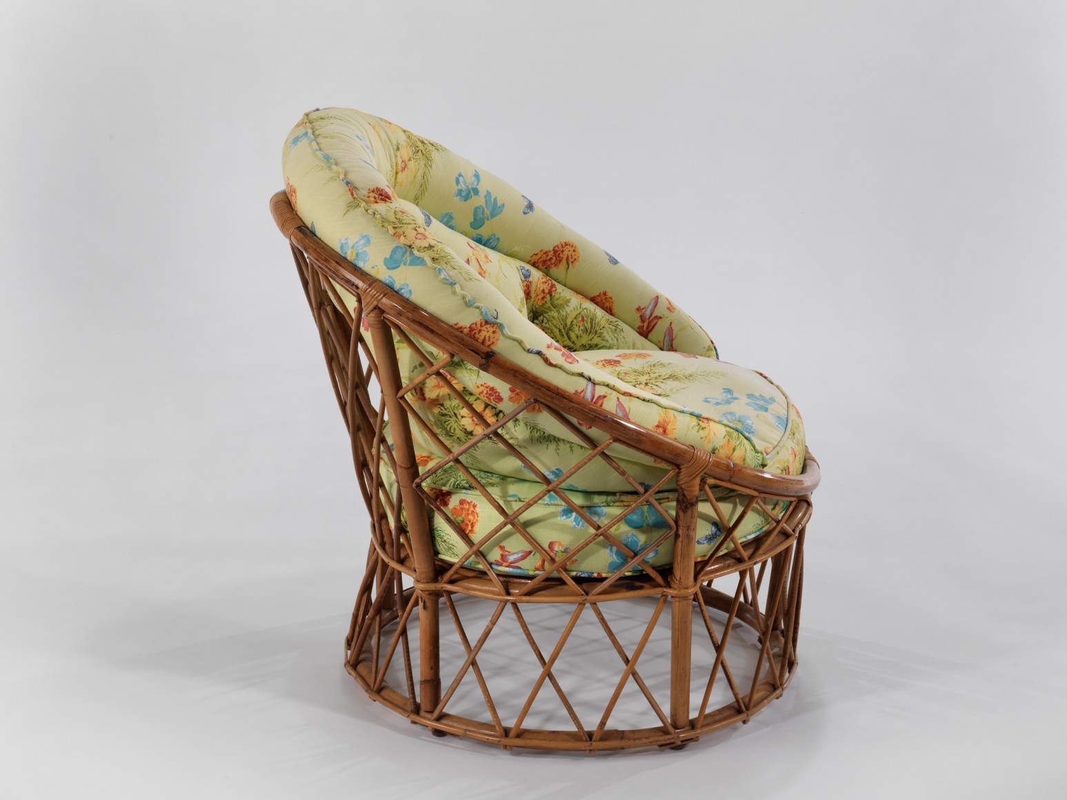 Cushion chair with floral motifs and wooden frame in front of white background