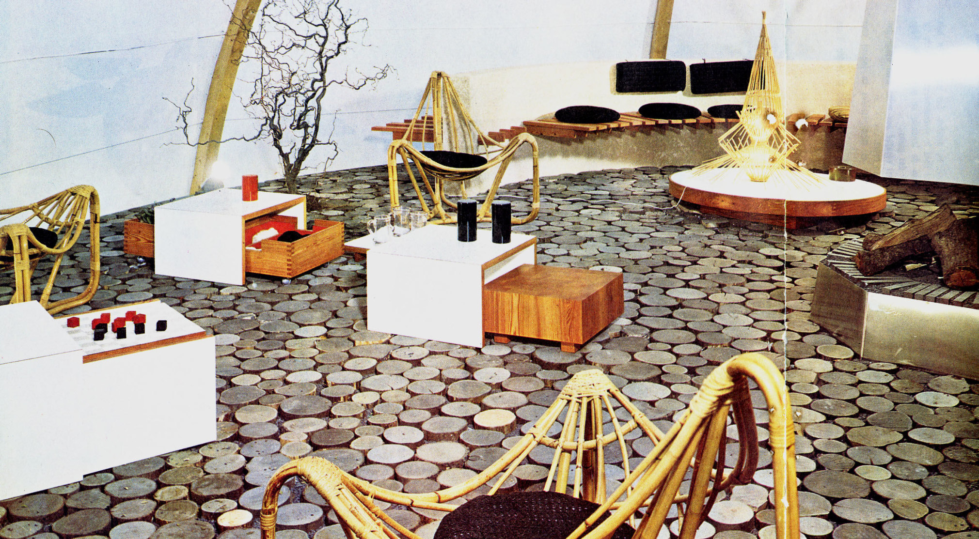 Archival photo of low rattan lounge chairs around low white wooden coffee tables at at a&nbsp;furniture fair in 1965