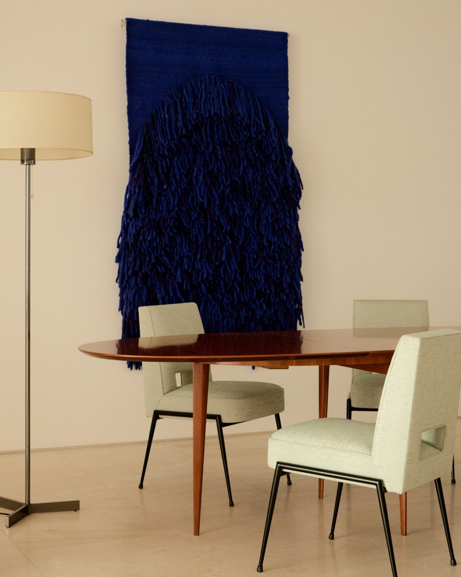 Blue woven wall hanging by Sheila Hicks, 6110 Floor Lamp by Roger Fatus, and Dining Table by Louis Sognot surrounded by dining chairs by Gustave Gautier