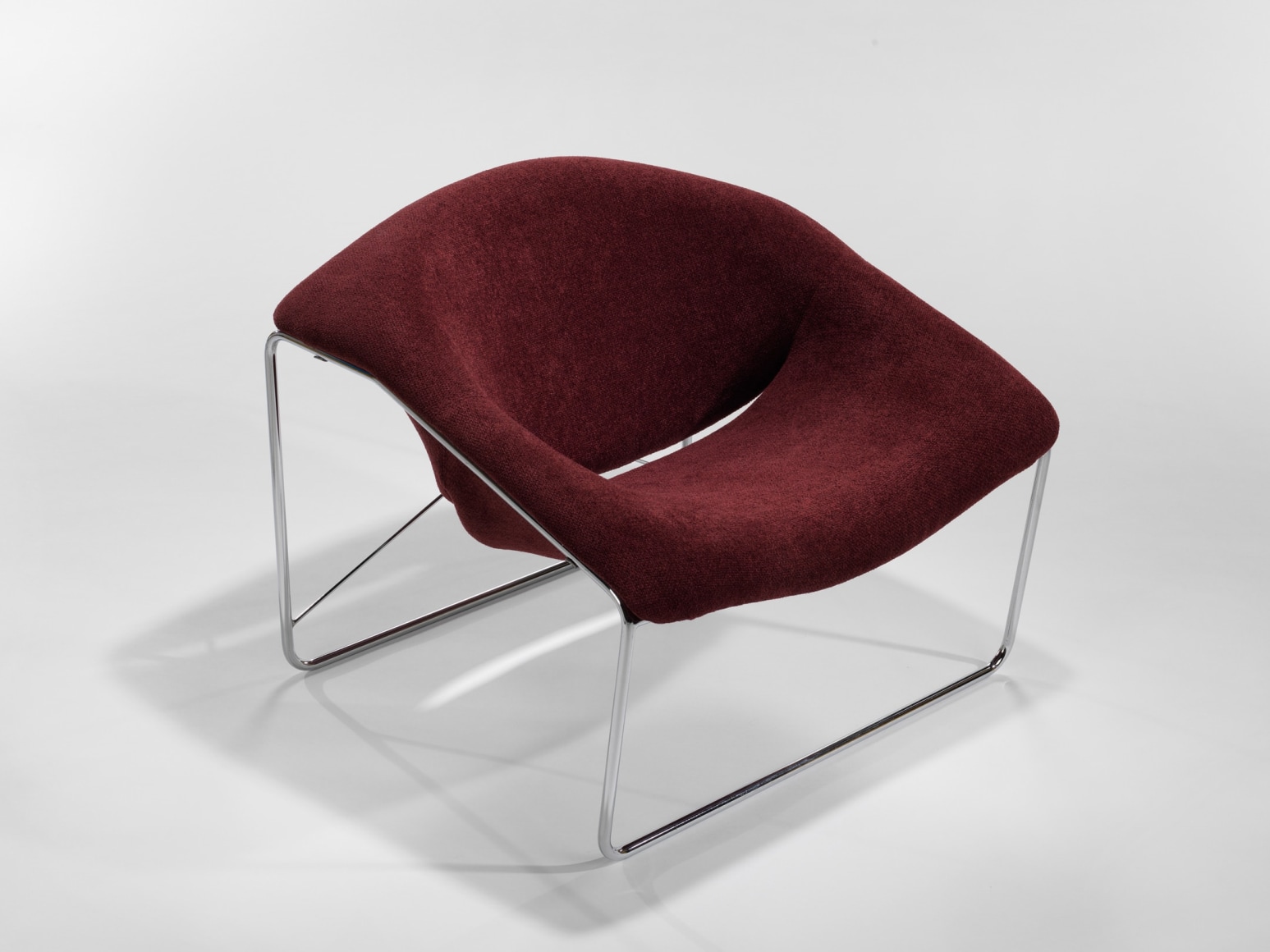 photograph of chair in a blank room with metal legs