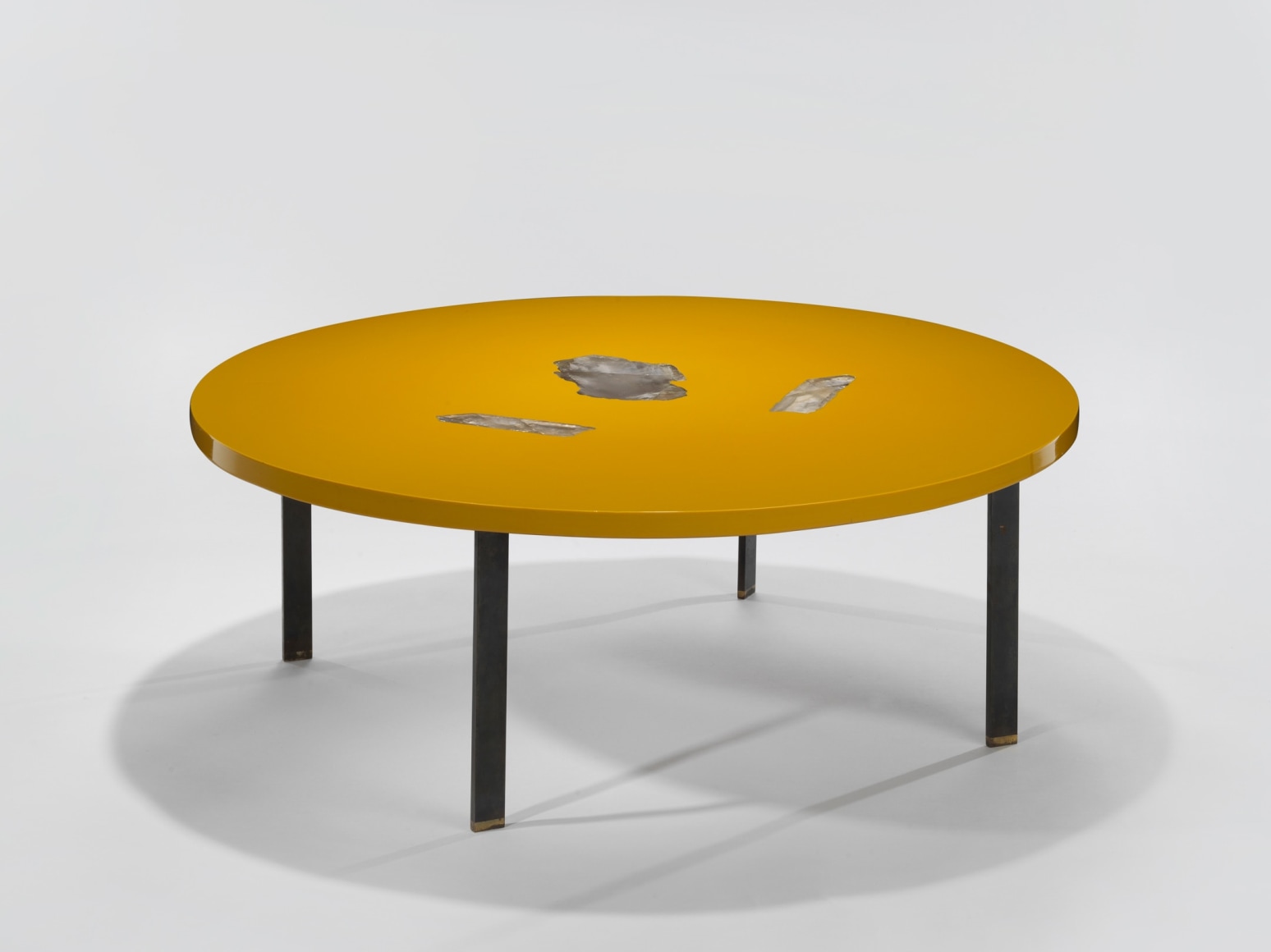 low yellow table with black legs in an empty room