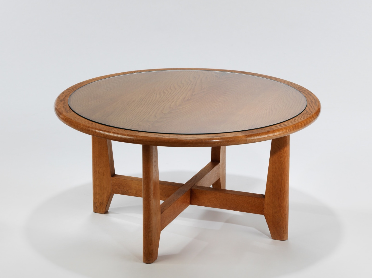 Wooden table with cross base and glass top by Renou and Genniset. View from far away.