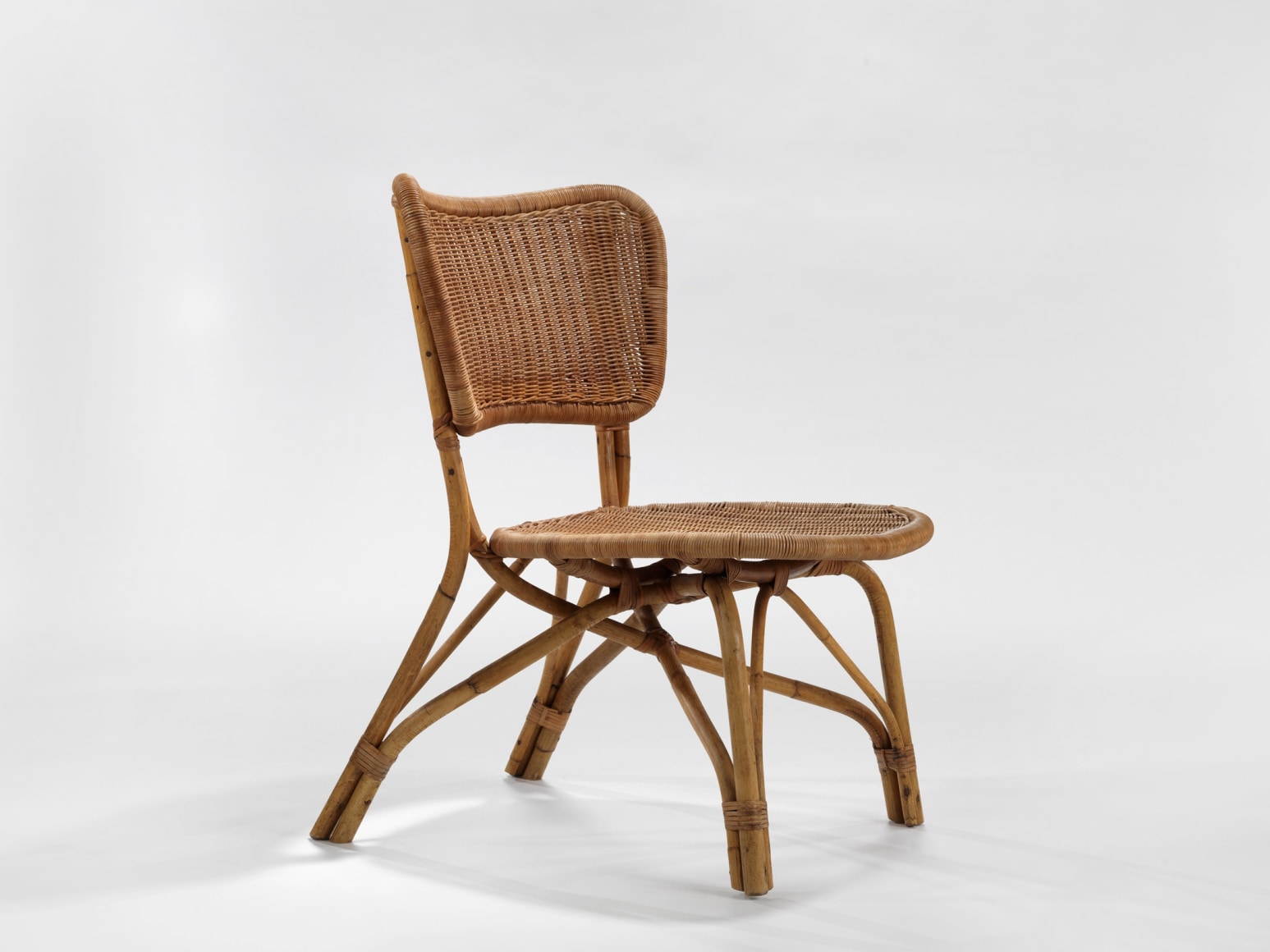 photograph of a rattan chair in a blank room