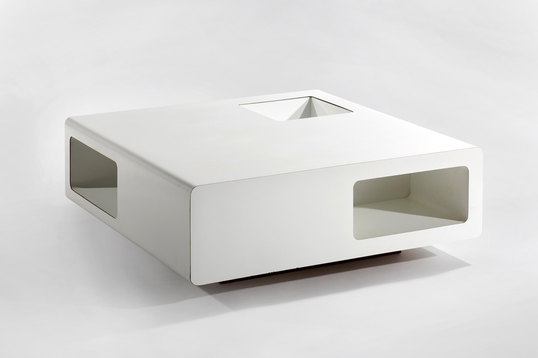 White formica low coffee table with cubbies and cut outs for storage