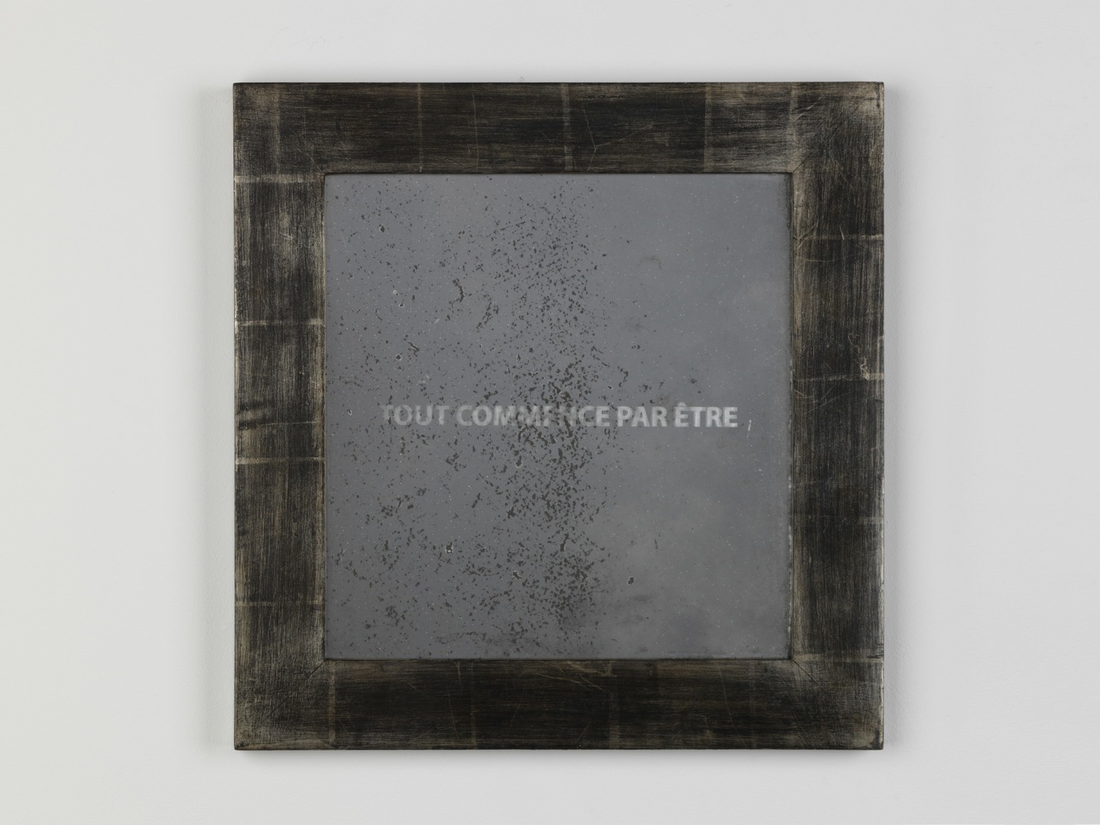 frame with the words 'tout commence par etre' written inside