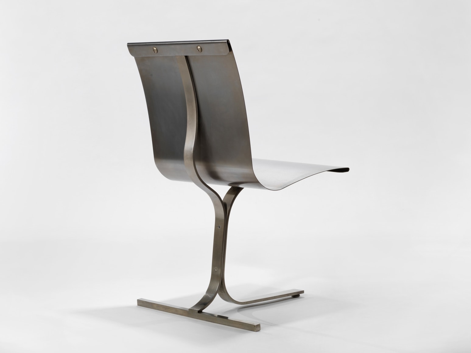 photograph of steel chair in a blank room