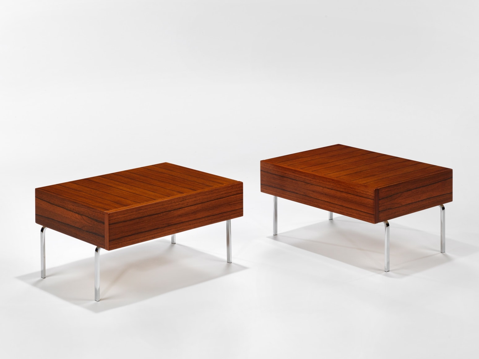 photograph of 2 side tables by Fermigier, tables have metal legs and teak tops
