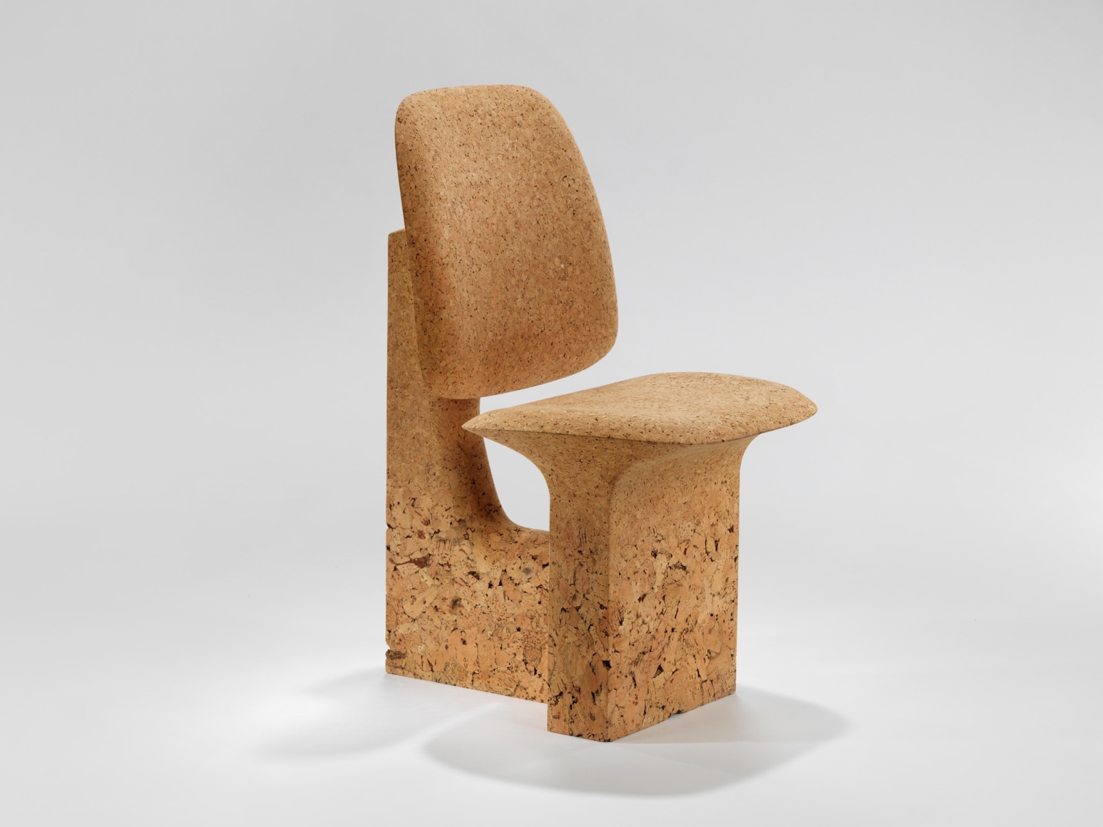 cork chair with great curves by made in situ. Image with grey background.