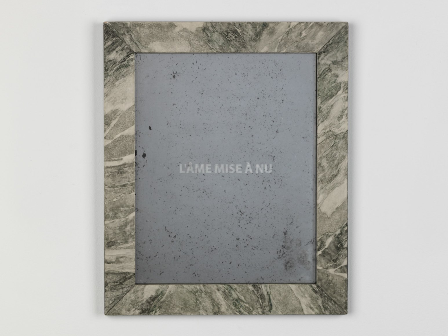 marbled frame hangs on a white wall