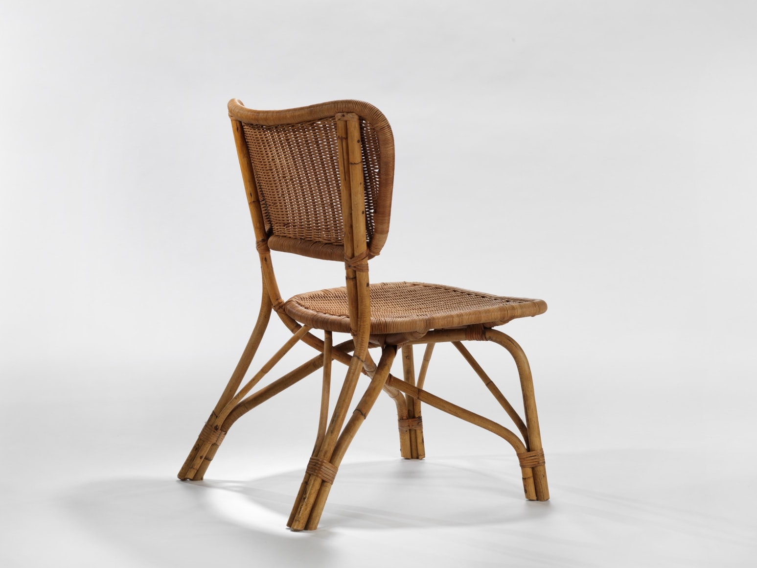 photograph of a rattan chair in a blank room