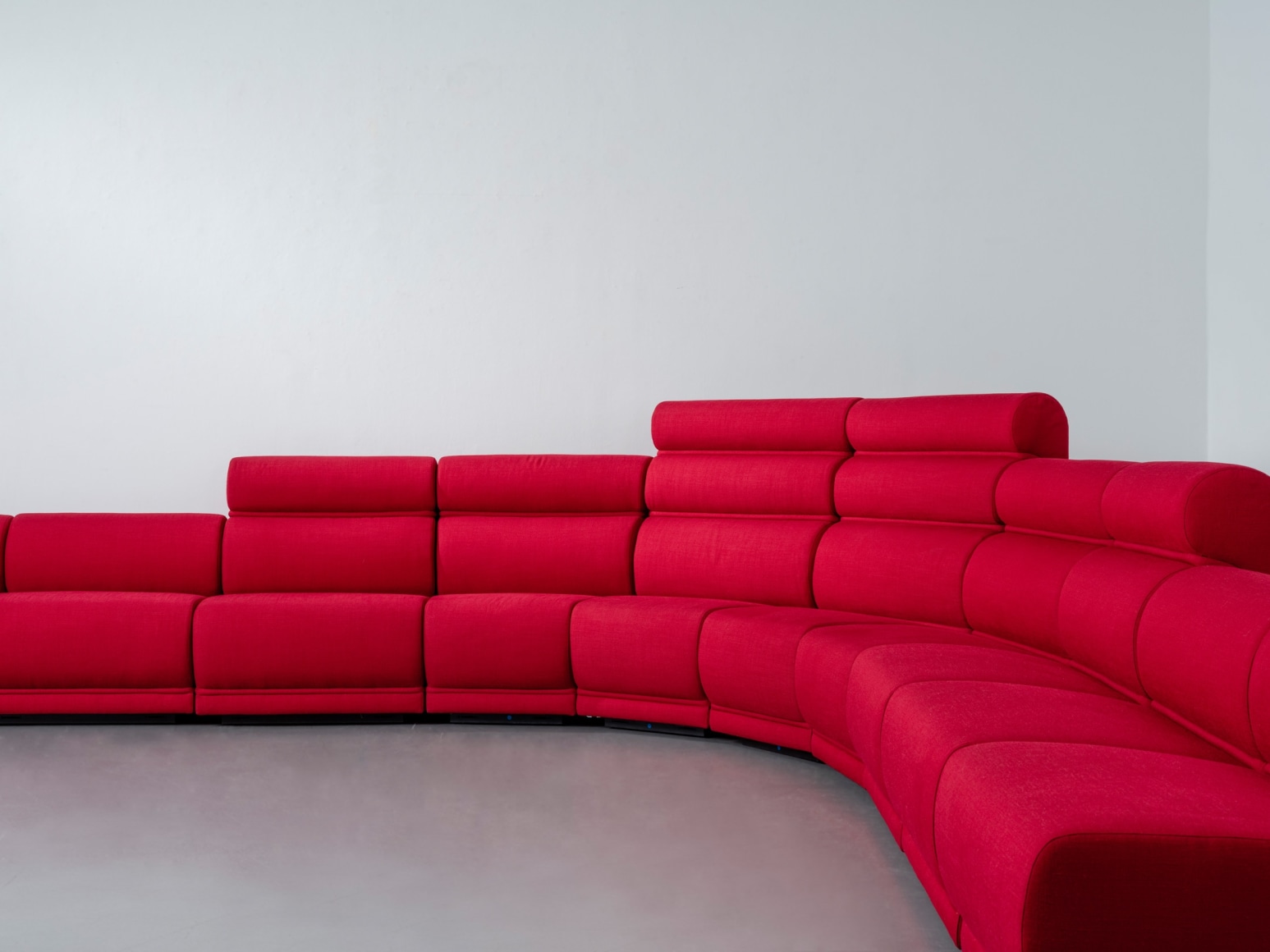 Red long huge sofa upholstered photo shots in a studio. Sofa is by Pierre Paulin.