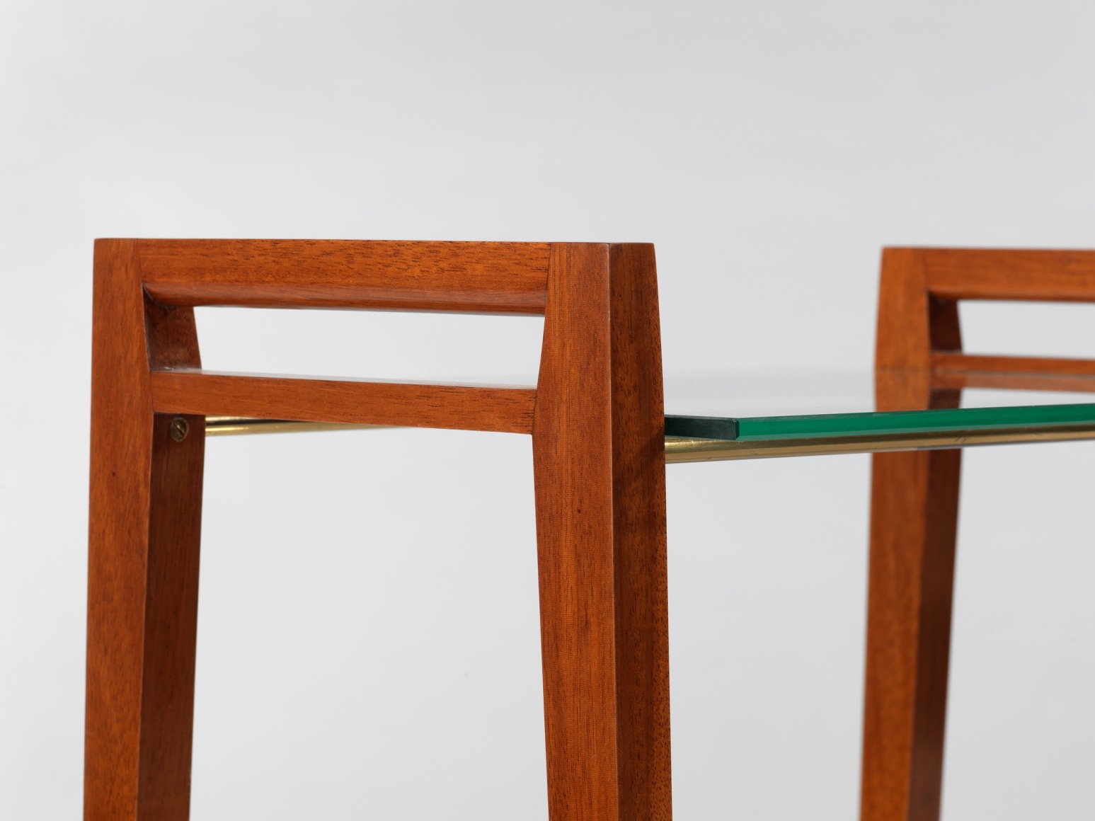 Two tier glass table with wooden legs in front of white background