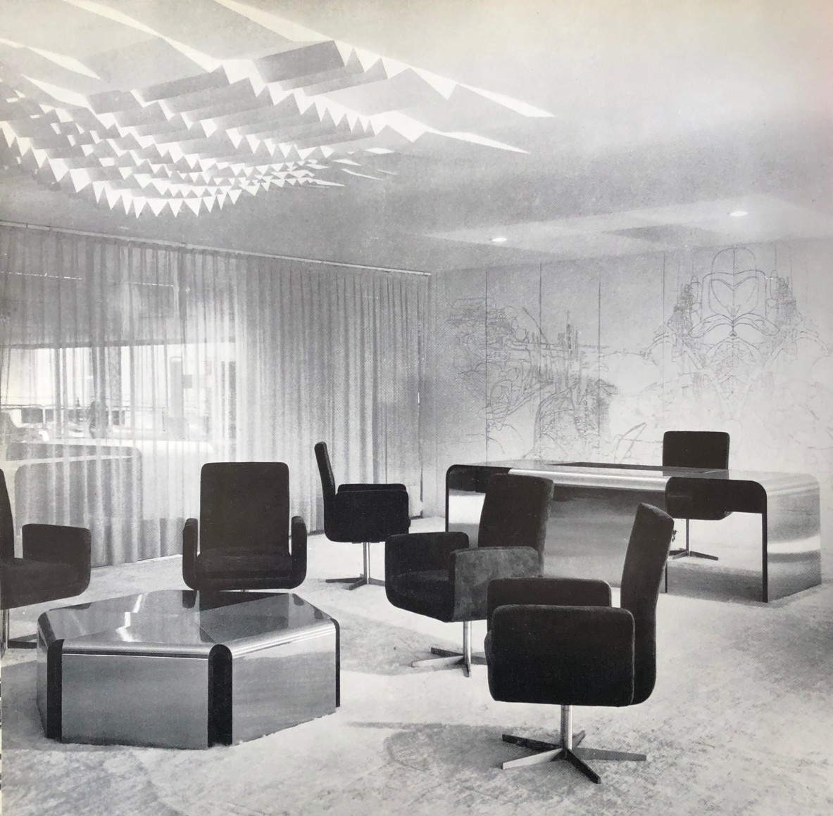 Archival image of the desk first designed and placed in a room. By Motte. Made of steel and wood.