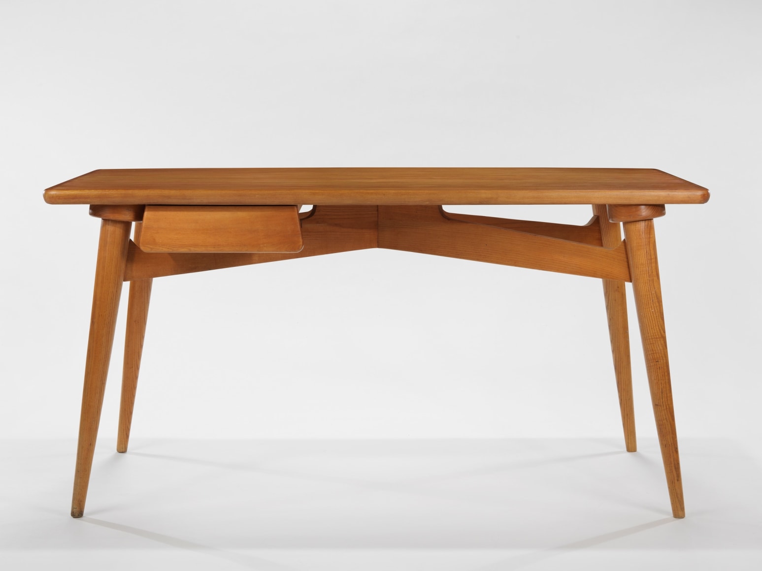 photograph of a wood desk in a blank room
