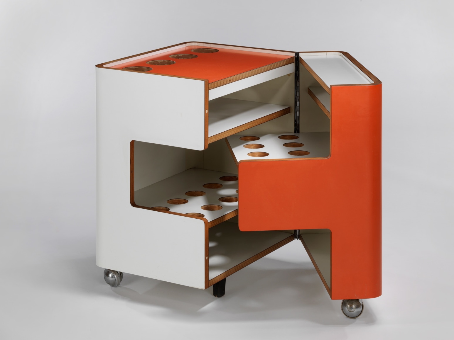 Bar cart in orange and white shown open and closed with different holes for various parts.