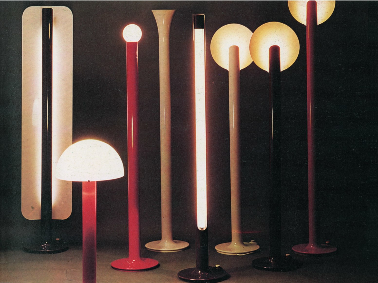 Grouping of floor lamps of various heights in black, red, and white with tulip bases