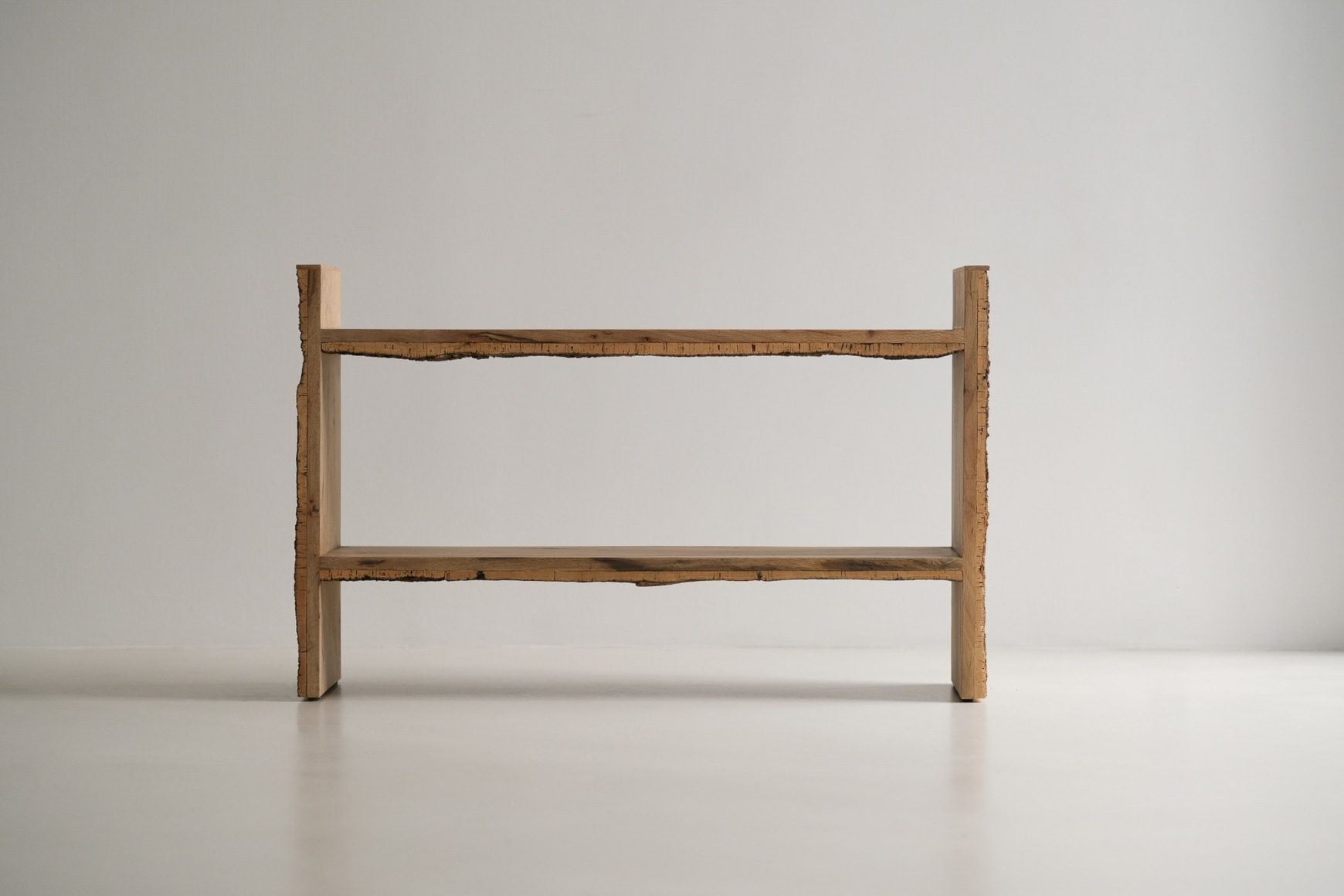 Bookshelf made of oak and cork standing against a grey background.