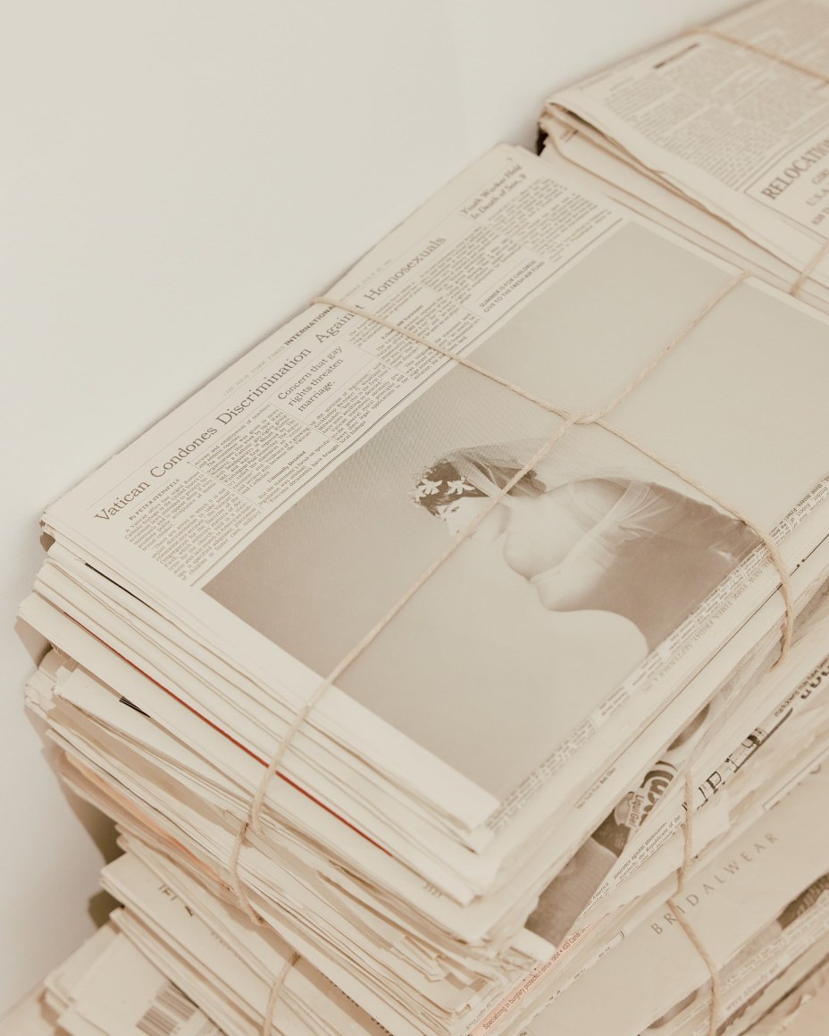 Robert Gober newspapers with various clippings and bundles in stacks.