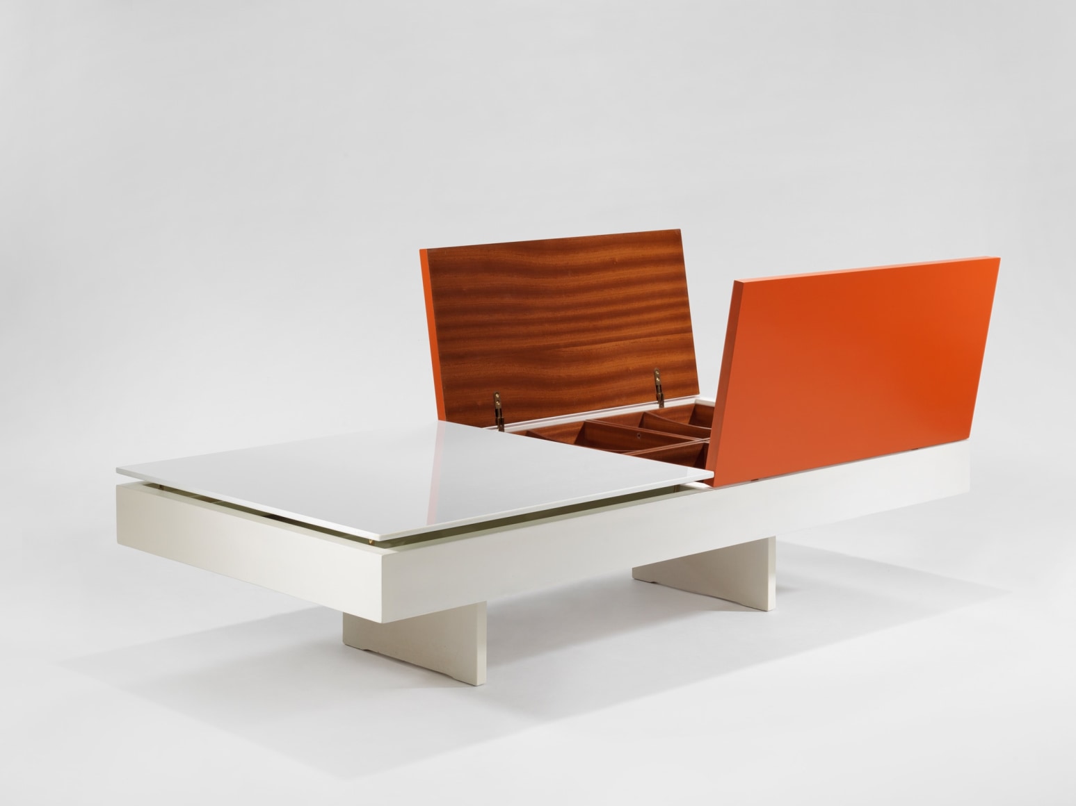 photograph of low table by Motte in a blank room, top of table is half orange and half white
