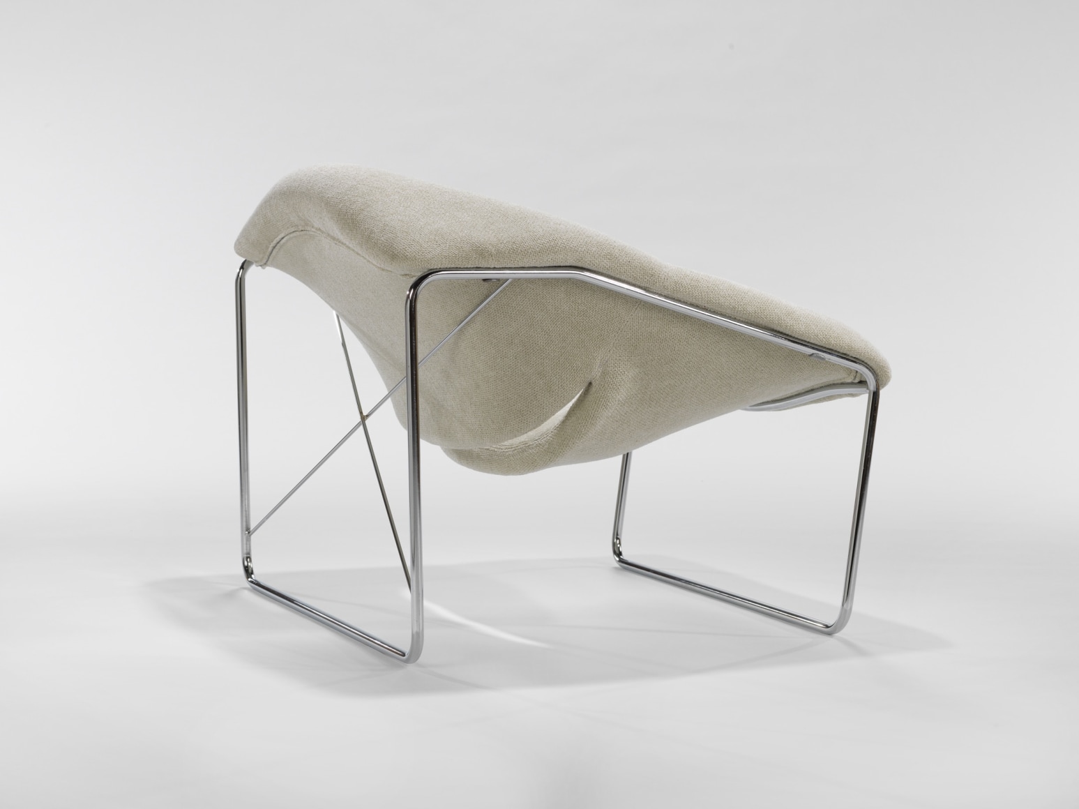 photograph of chair in a blank room with metal legs