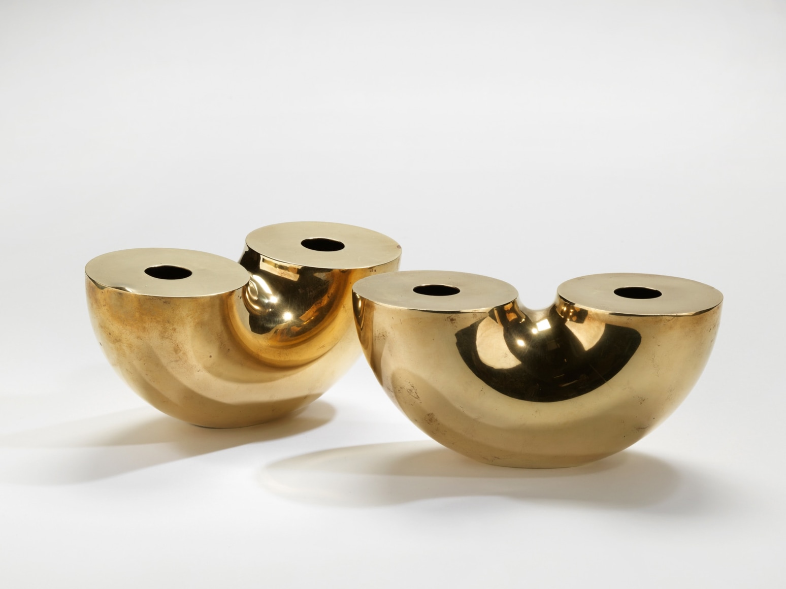 photograph of two gold vases in a blank room