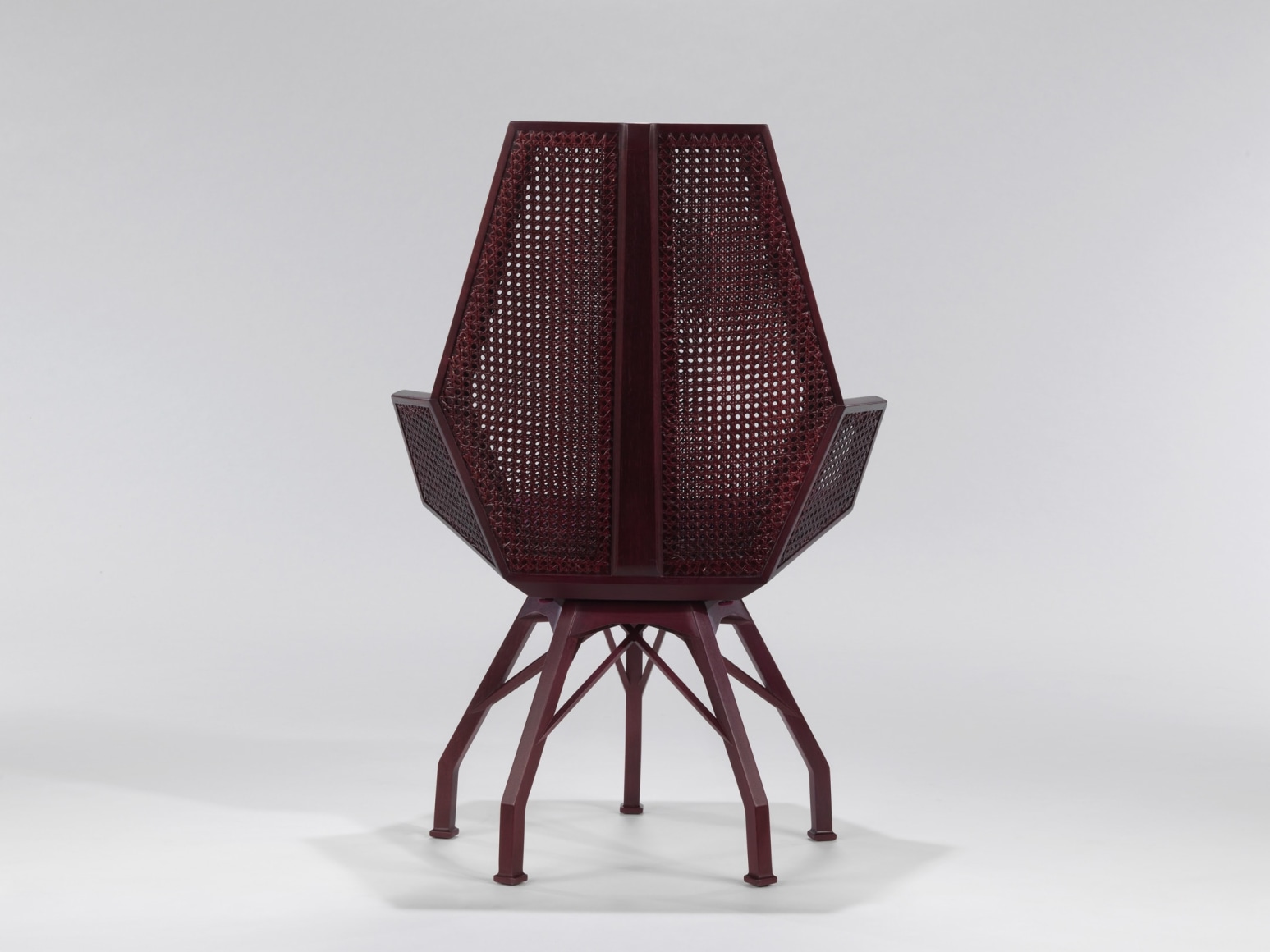 Back view of caned desk chair with red upholstered seat by Pierre Paulin