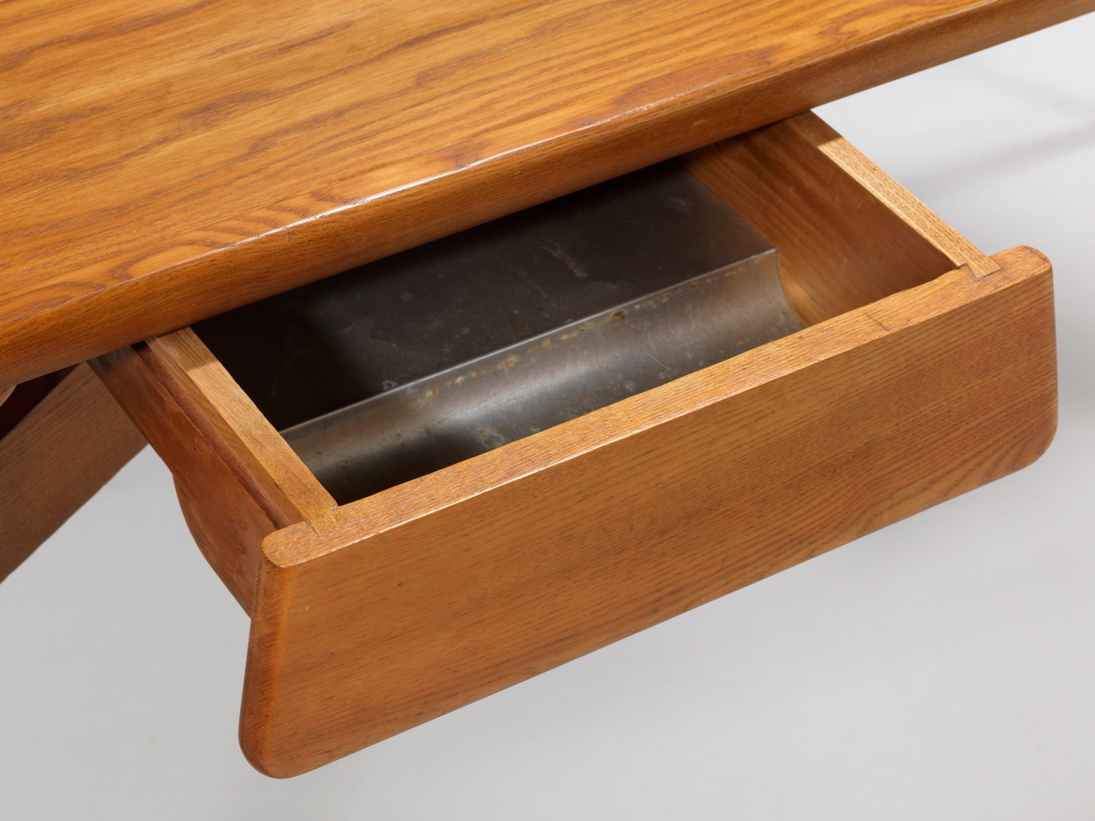 photograph of a wood desk in a blank room