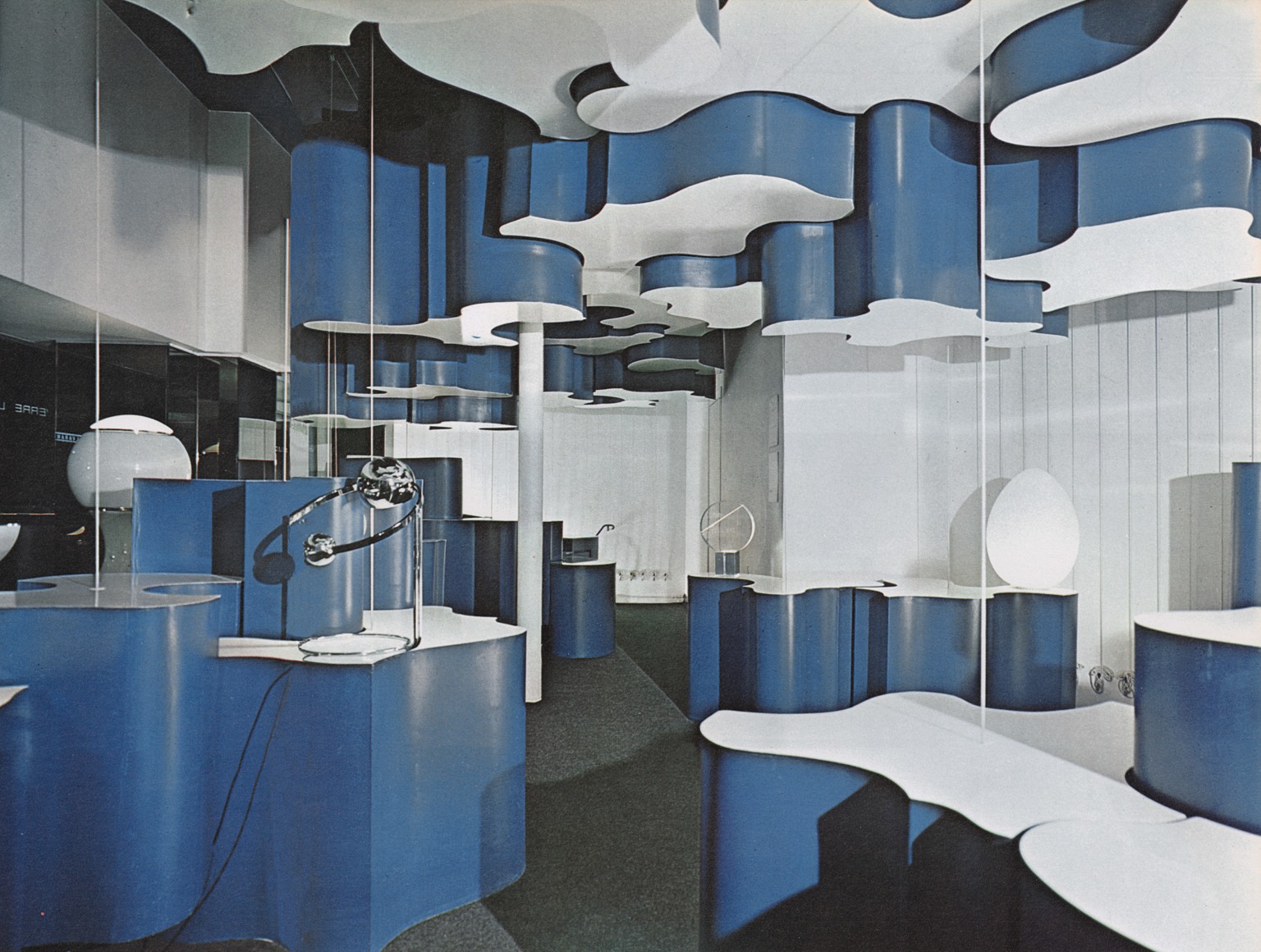 Archival photo of the Verre Lumiere Shop in Paris with various blue and white tiered displays for table lamps