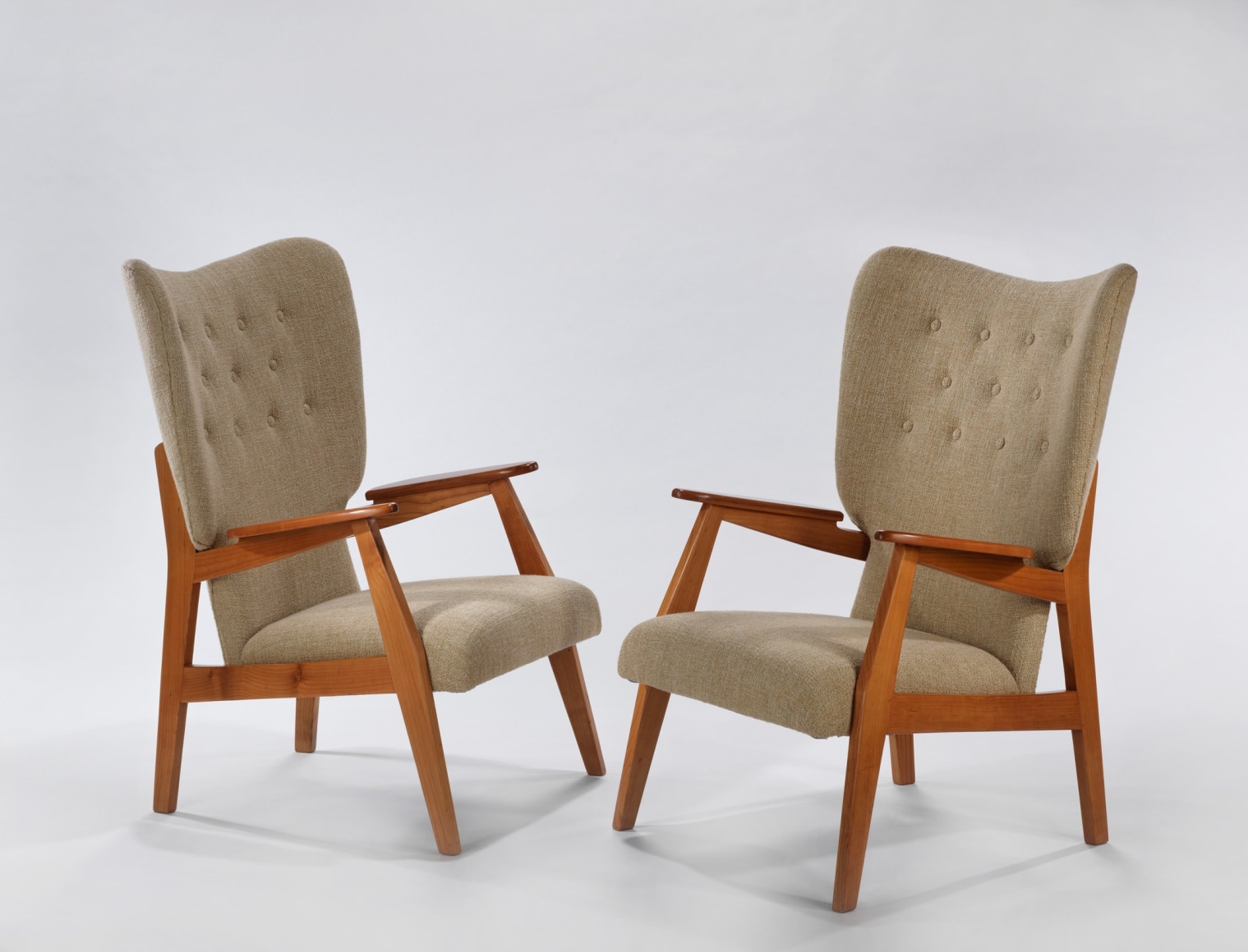 Pair of cream upholstered chair with wood arms facing each other by Ren&eacute;-Jean Caillette