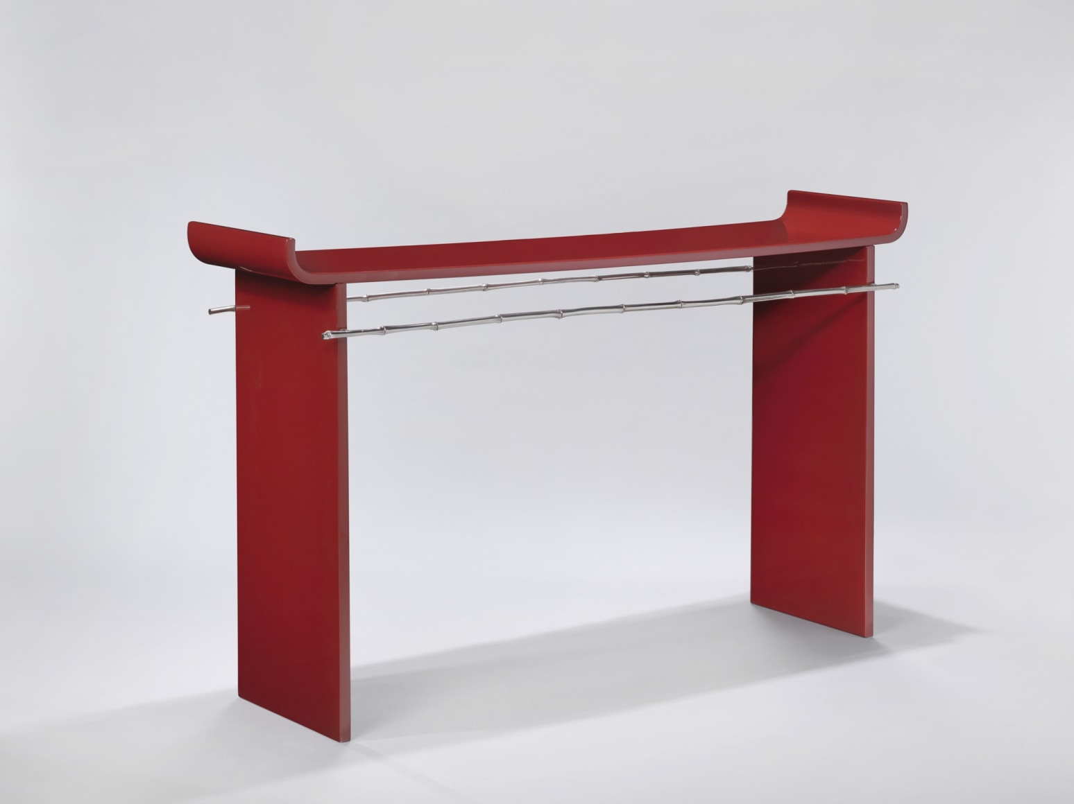 Red lacquer console table by Maria Pergay with image from the angle.