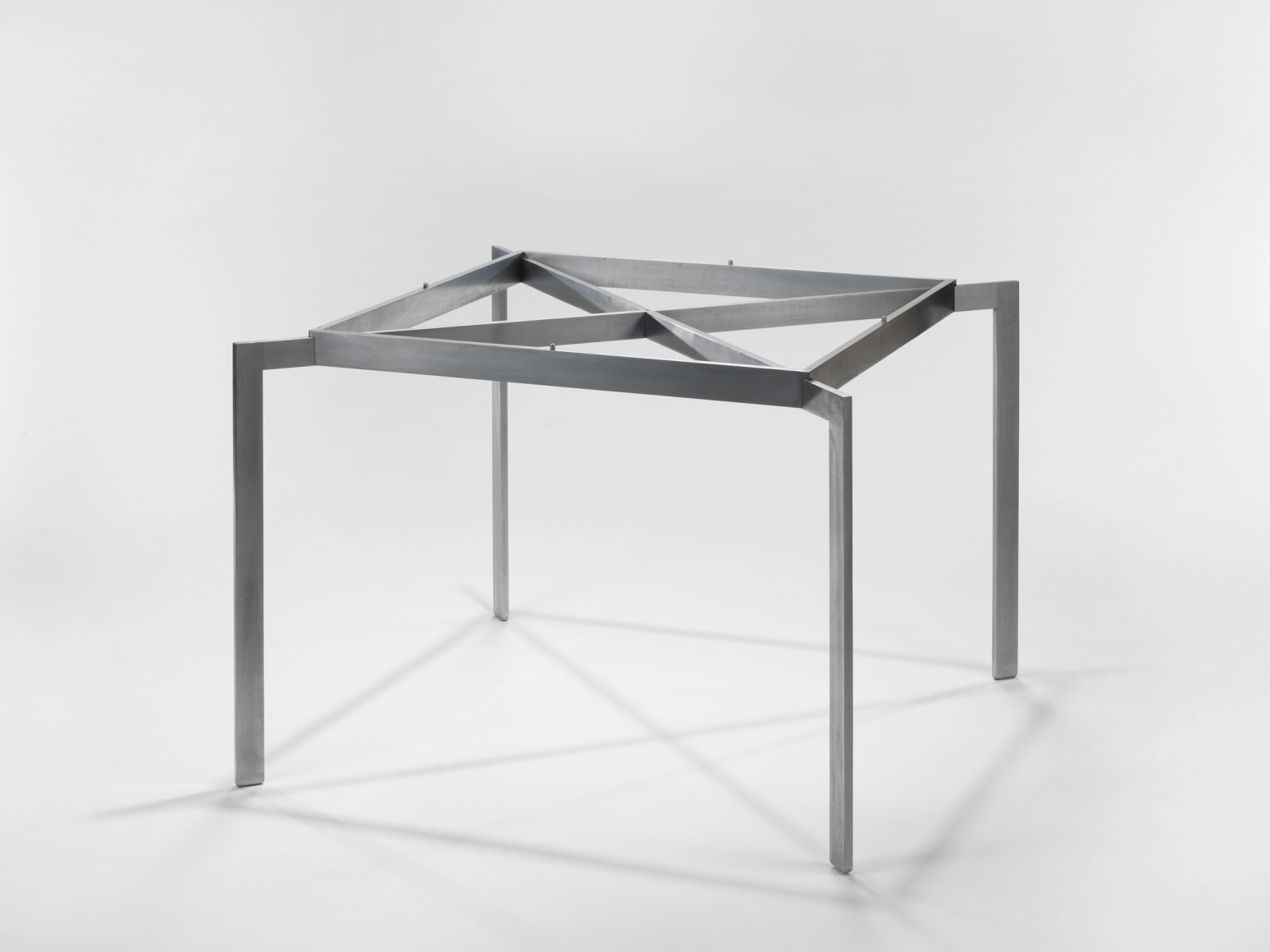 photograph of a table with steel legs in a blank room